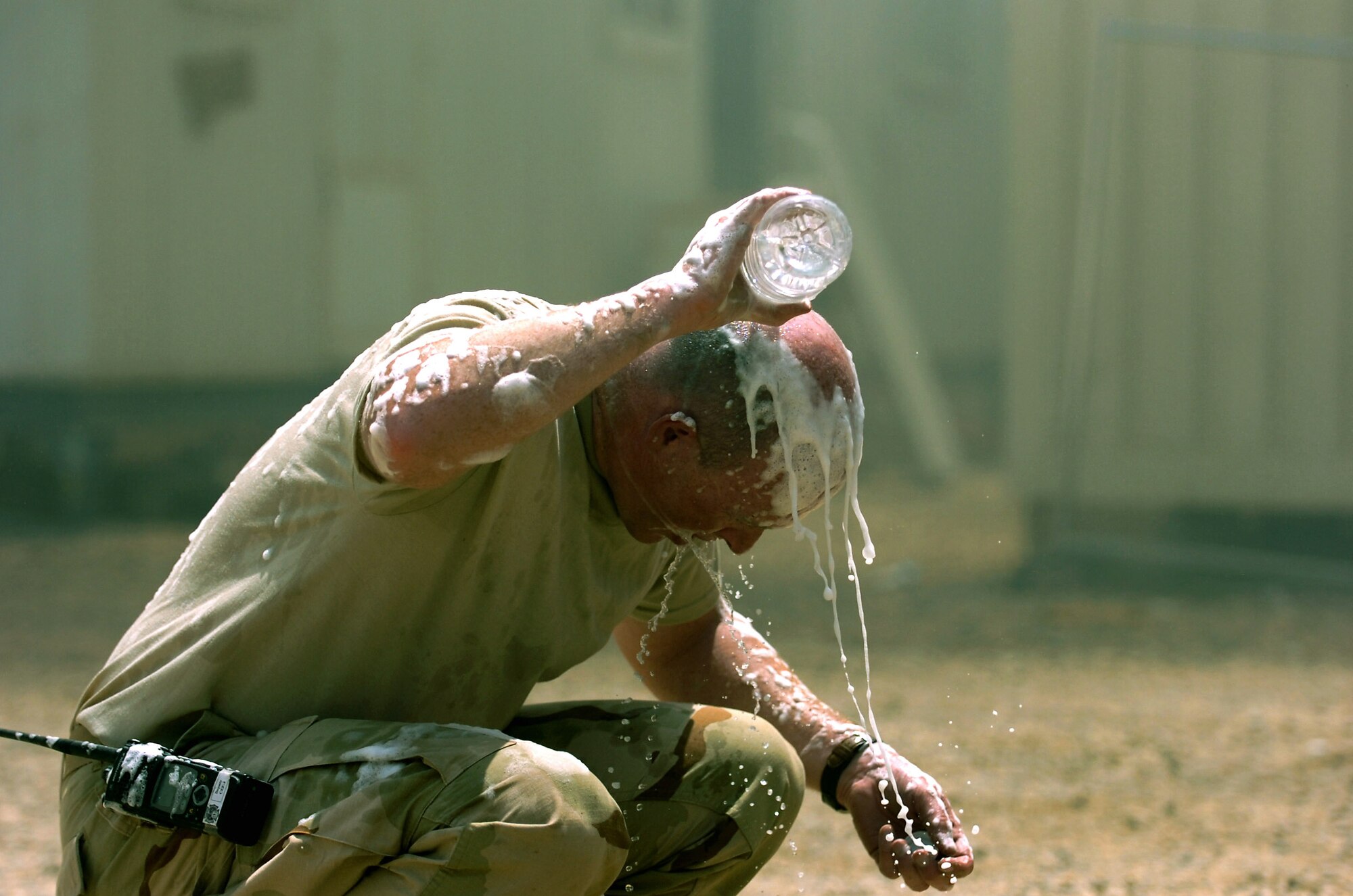Master Sgt. David Clifford washes off firefighting foam after battling a two-alarm fire July 22 at Joint Base Balad, Iraq. The foam helped extinguish a fire that destroyed several metal framed buildings used as living quarters and supply storage units. Sergeant Clifford, the Joint Base Balad Fire Department assistant fire chief, is deployed from Tyndall Air Force Base, Fla. (U.S. Army photo/Sgt. Gary Hawkins) 