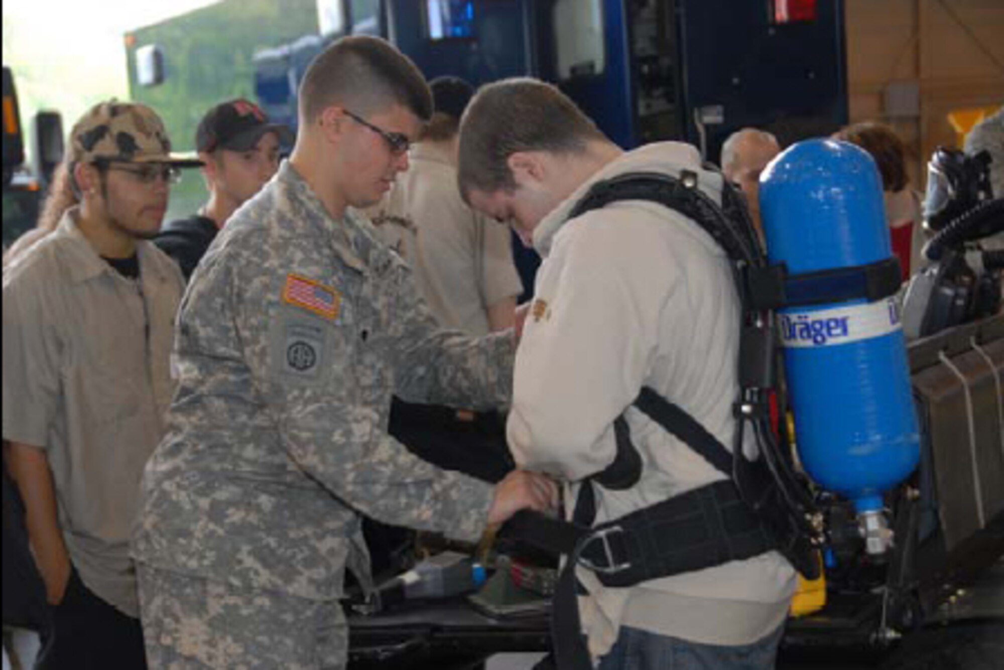 Specialist Nick Drake, 14th Civil Support Team, Army Aviation Support Facility, Windsor Locks, Conn., assists a student from Platt Technical High School fasten a breathing apparatus during Career Day at Bradley Air National Guard Base on May 8, 2008. (U.S. Air Force photo by Master Sgt. Jeanne E. Daigneau)