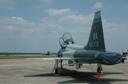 A Randolph Air Force Base T-38 Talon sits on the flight line at Tyndall Air Force Base, Fla., while an F-22 Raptor taxis for takeoff July 18. Pilots from the 435th Flying Training Squadron here, were asked to play the aggressing force against pilots from the 325th Fighter Wing in a week-long sortie training mission. Tasking the T-38s to act as the aggressors cost 85 percent less in fuel and operating expenses than using either F-15s or F-16s. (U.S. Air Force photo by Airman 1st Class Veronica McMahon)