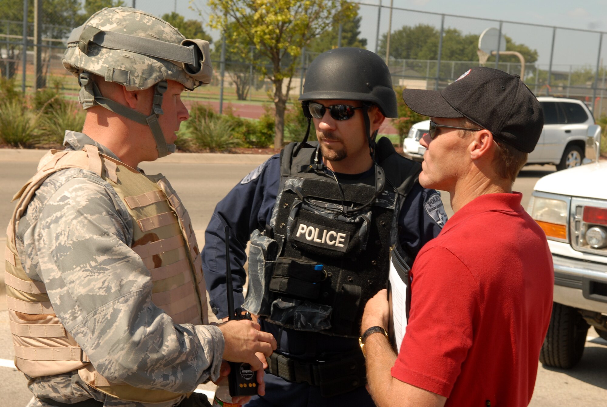 From left to right: Capt. Brian Copper, 17th Security Forces Squadron, San Angelo Police Department Lt. Tracy Fincher and SAPD Lt. Jeff Fant confer during the hostage situation. (U.S. Air Force photo by Staff Sgt. John Barton)