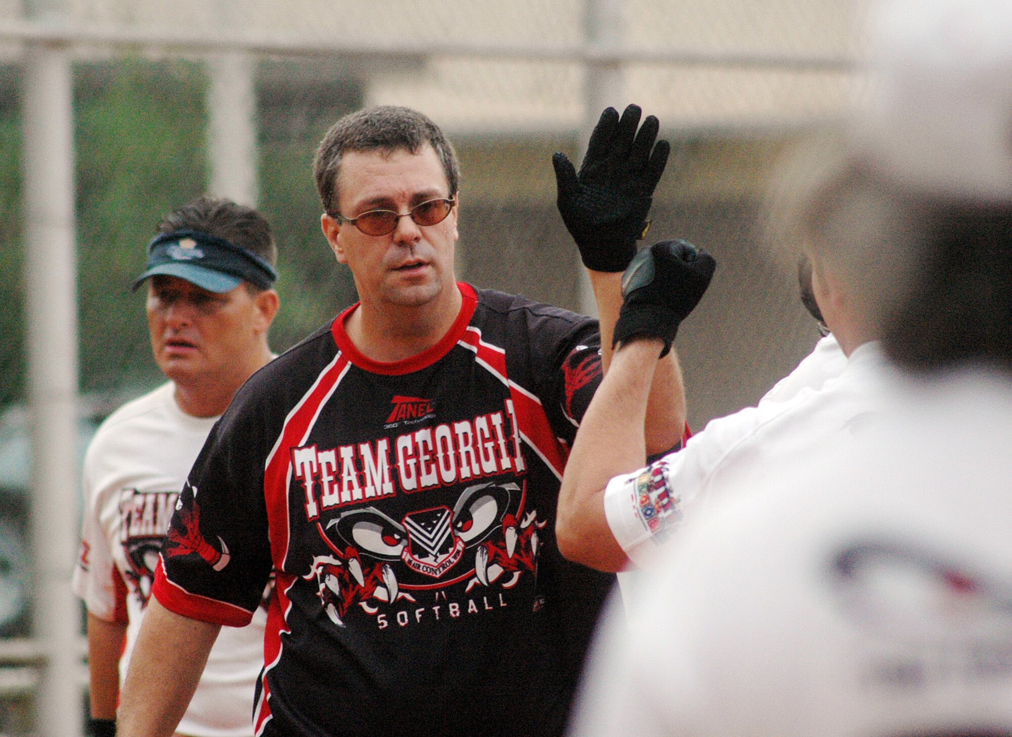 116th Maintenance Squardon's Russ Hearst slaps high fives after hitting his second home run of the game. In addition to his offensive fire power, he allowed just four runs in the final five innings as the team's pitcher. U. S. Air Force photo by Sue Sapp