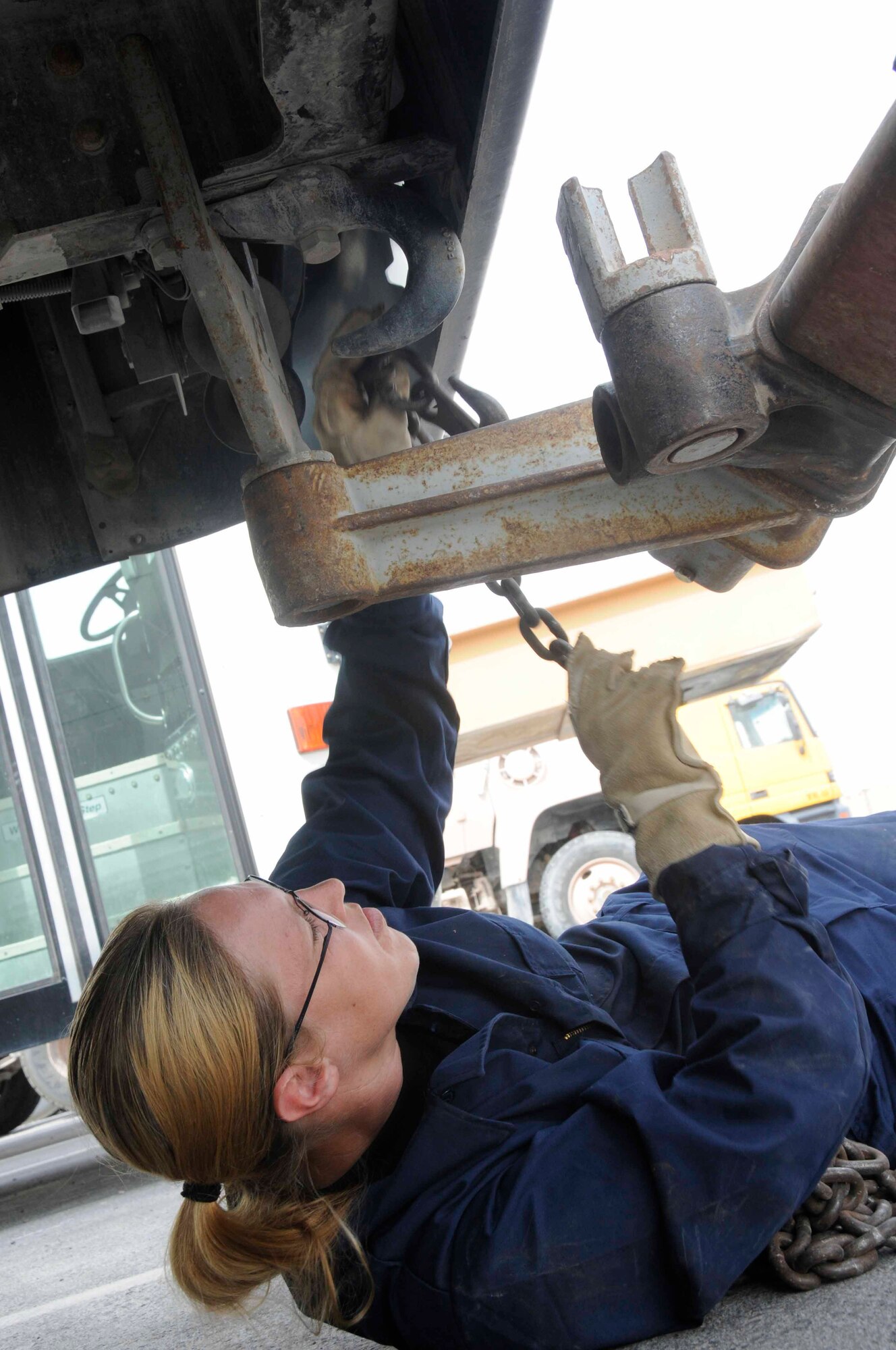 Gwen Crowder, 379th Expeditionary Logistics Readiness Squadron, secures chains from a Zachlift to a bus July 22 in Southwest Asia. Gwen is a vehicle operator from Kileen, Texas. (U.S. Air Force Photo/Staff Sgt. Darnell T. Cannady)