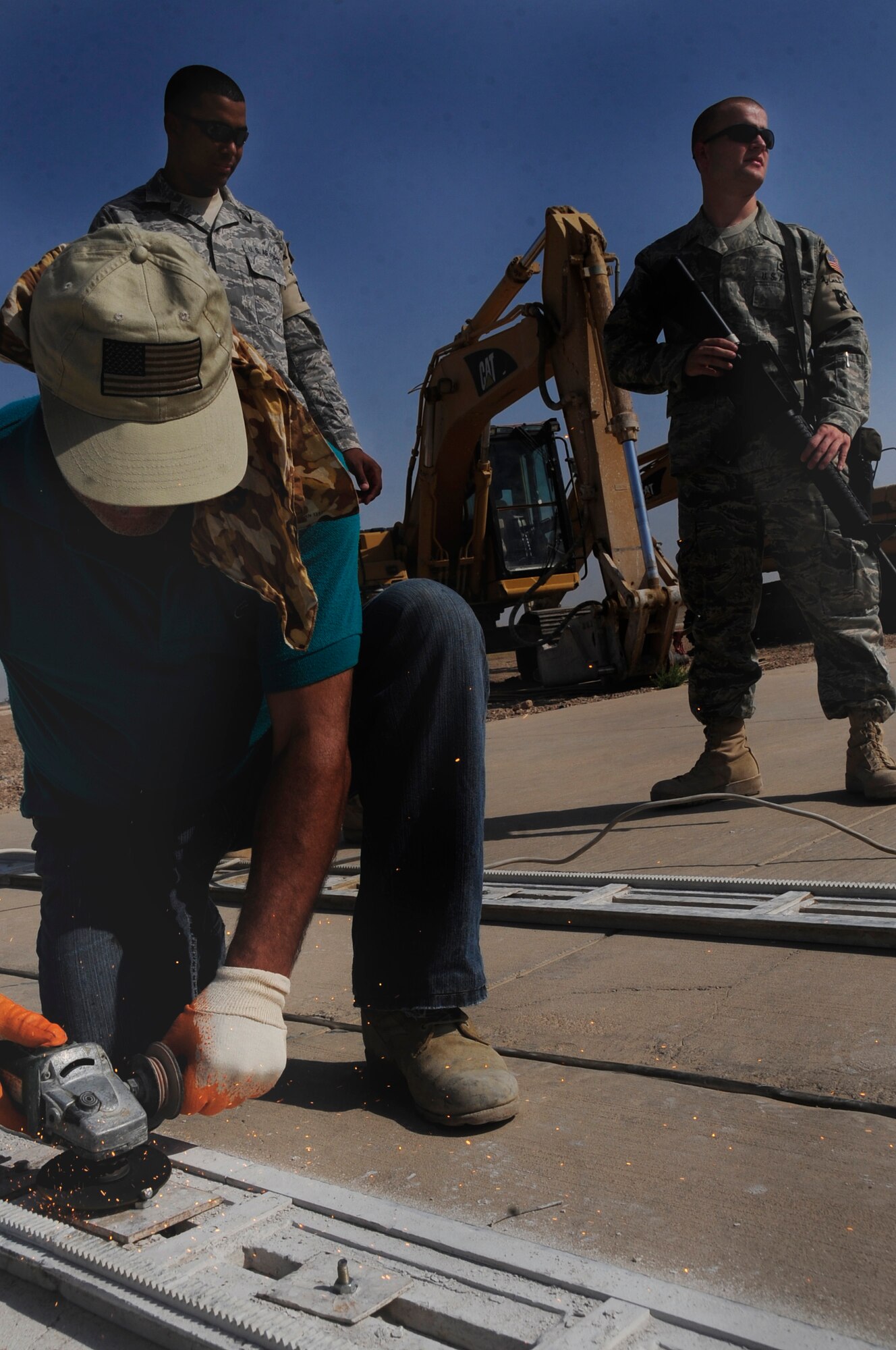 ALI BASE, Iraq -- Airman 1st Class Nathaniel Gonzalez and Airman 1st Class Lawrence Moore, 407th Expeditionary Security Forces Squadron, stand guard watching third country nationals here July 24, 2008. Airmen working in the 407th ESFS Force Protection Section are tasked with maintaining the installation's internal safety. Both airmen are deployed from the 28th Bomb Wing, Ellsworth Air Force Base, S.D., where Airman Gonzalez works in aerospace propulsion and Airman Moore works as a wing postal clerk. (U.S. Air Force photo/Airman 1st Class Chris Griffin)