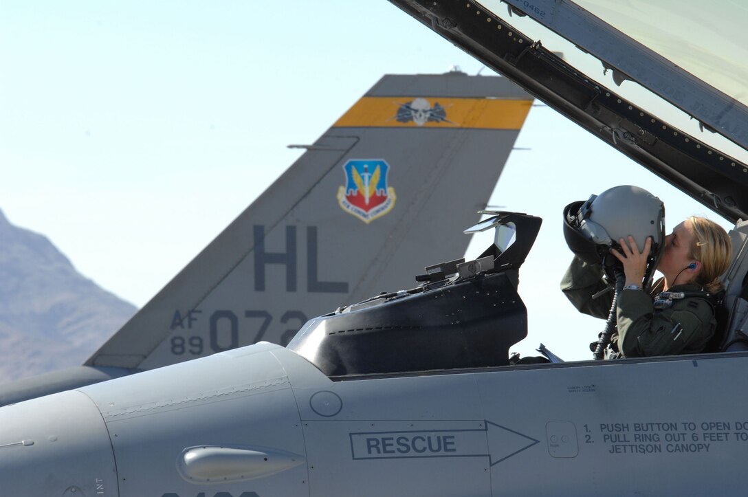 Capt. Jennifer Wade puts on her flight helmet July 22 before a training mission during Red Flag at Nellis Air Force Base, Nev. Capt. Wade is a F-16 Fighting Falcon pilot assigned to Hill AFB, Utah. (U.S. Air Force photo/Senior Airman Larry E. Reid Jr.)