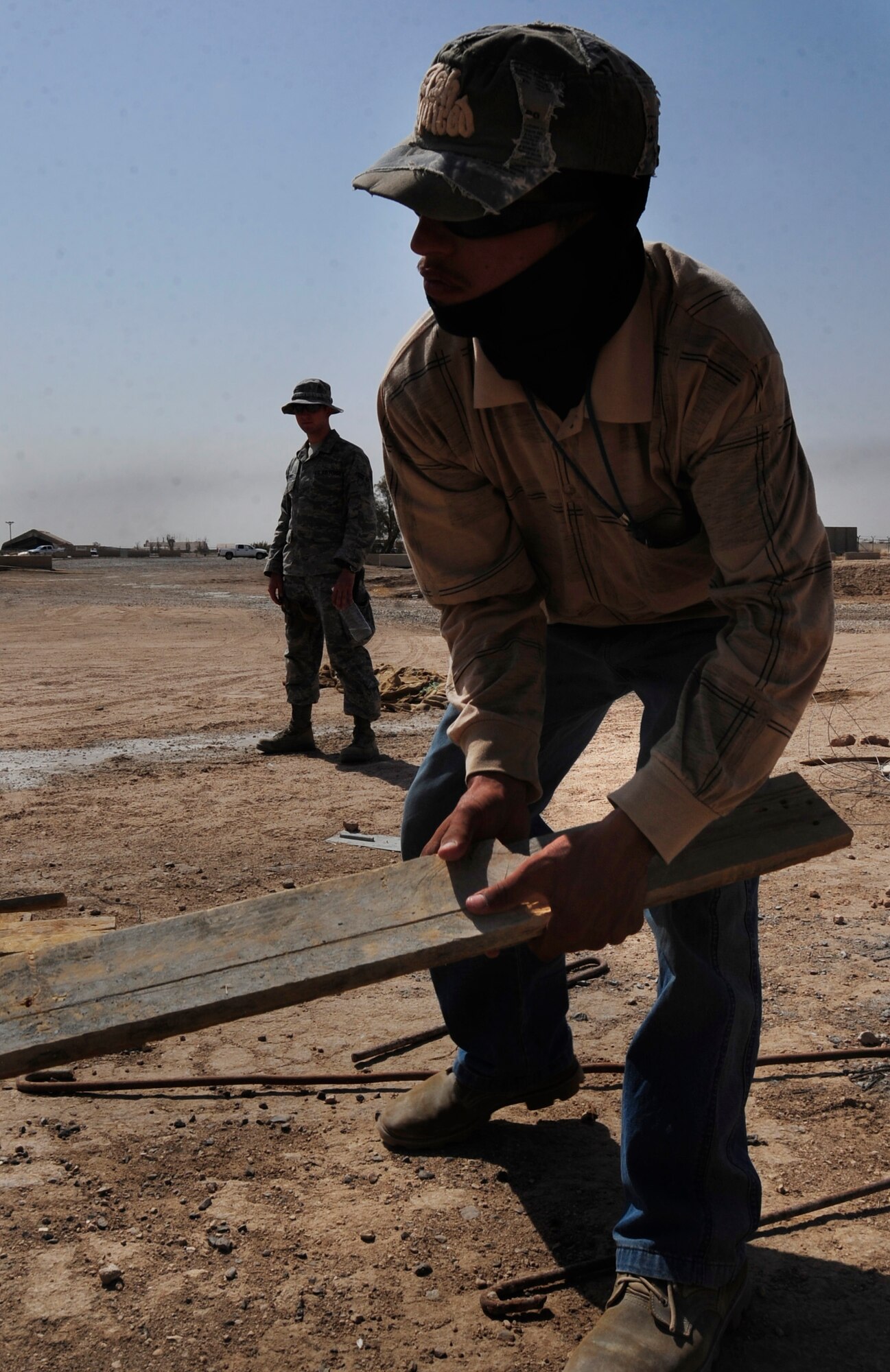 ALI BASE, Iraq -- Airman 1st Class Adam McKee, 407th Expeditionary Security Forces Squadron, watches over a third country national as he works July 24, 2008. Airmen in the Force Protection Section are tasked with maintaining the installation's internal safety. In addition to their attendant duties, FP escorts compliment security forces in securing coalition assets and personnel while enabling the group's mission. Airman McKee is deployed from 28th Communications Squadron at Ellsworth Air Force Base, S.D. (U.S. Air Force photo/Airman 1st Class Chris Griffin)