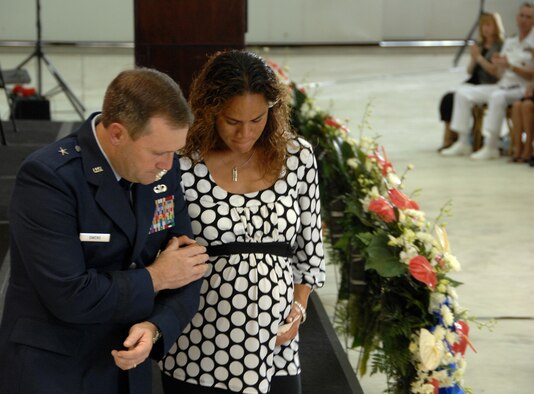 Brig. Gen. Douglas Owens, 36th Wing commander, assists Ursula Martin, wife of Col. George Martin, 36th Medical Group deputy commander, during a memorial ceremony Friday at Hangar One here. Colonel Martin and five other Airmen lost their lives when their B-52H Stratofortress “Raider 21” crashed 25 miles off the coast of Guam. (U.S. Air Force photo by Airman 1st Class Courtney Witt) 
