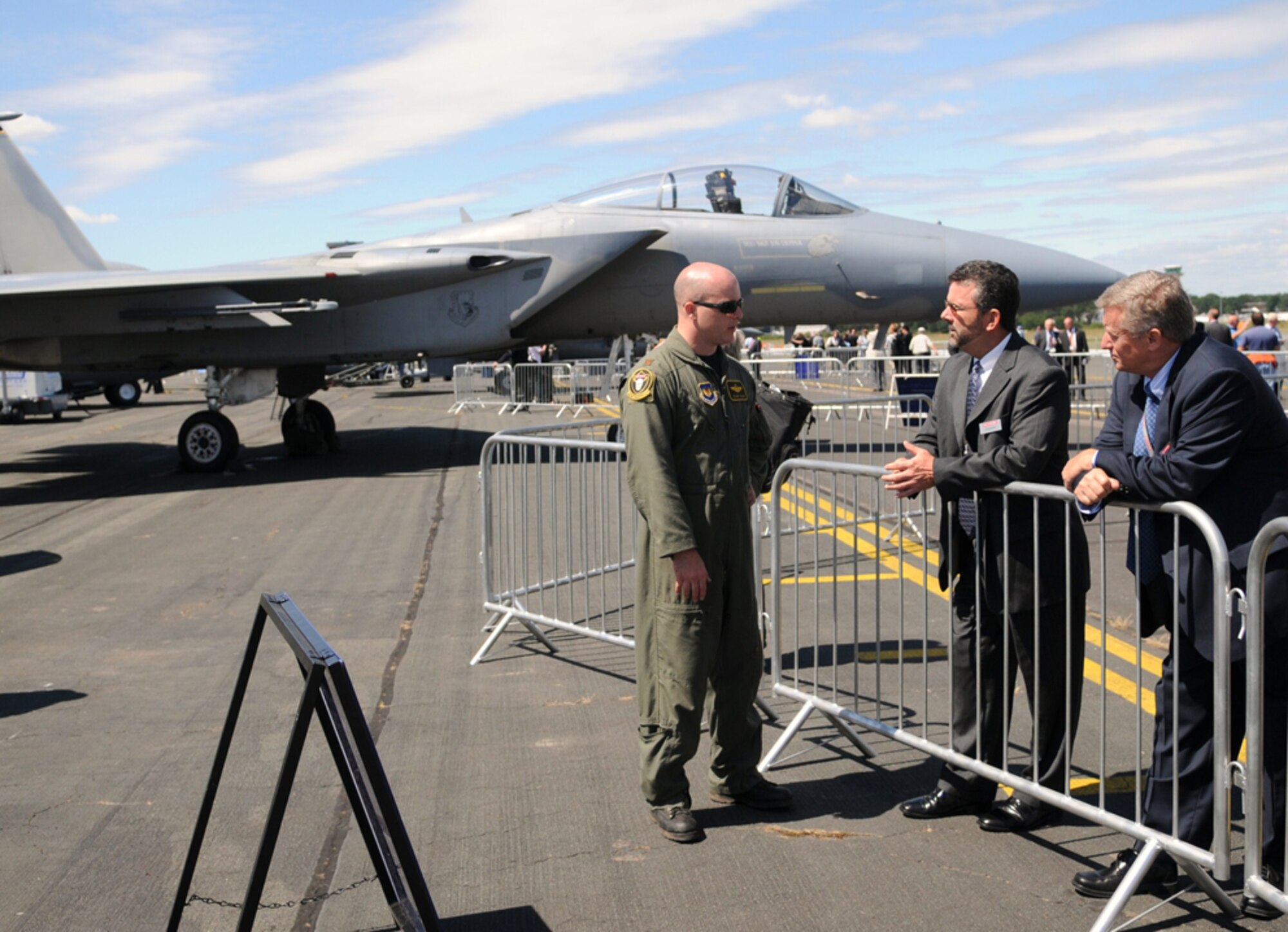 Maj. Roland Hillier of Lakenheath Air Force Base, United Kingdom, explains to Joe McCarthy (left) and Joe Senftle of BAE Systems how Data Link gives pilots better situational awareness.  More than 50 U.S. military personnel, including six McChord Air Force Base air crew members, deployed here to support the trade show and airshow July 14-20.  U.S. military presence at the event helps to promote standardization and interoperability of equipment with NATO allies as well as demonstrate that U.S. industry is producing equipment critical to the success of current and future military operations. (U.S. Air Force photo by 2nd Lt. Kathleen Ferrero) 