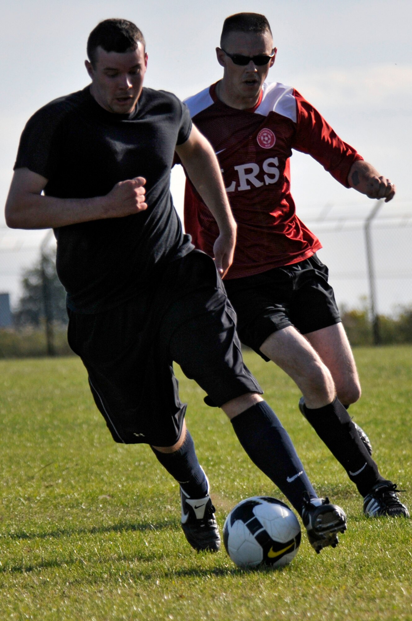 Casey Mckinney 48th Logistics Readiness Squadron soccer team chases down Jacob Biar, 48th Security Forces Squadron Soccer team July 21 at RAF Lakenheath, England. LRS shut out SFS 3 to 0 in the first playoff game. (U.S. Air Force photo by Airman Perry Aston) 