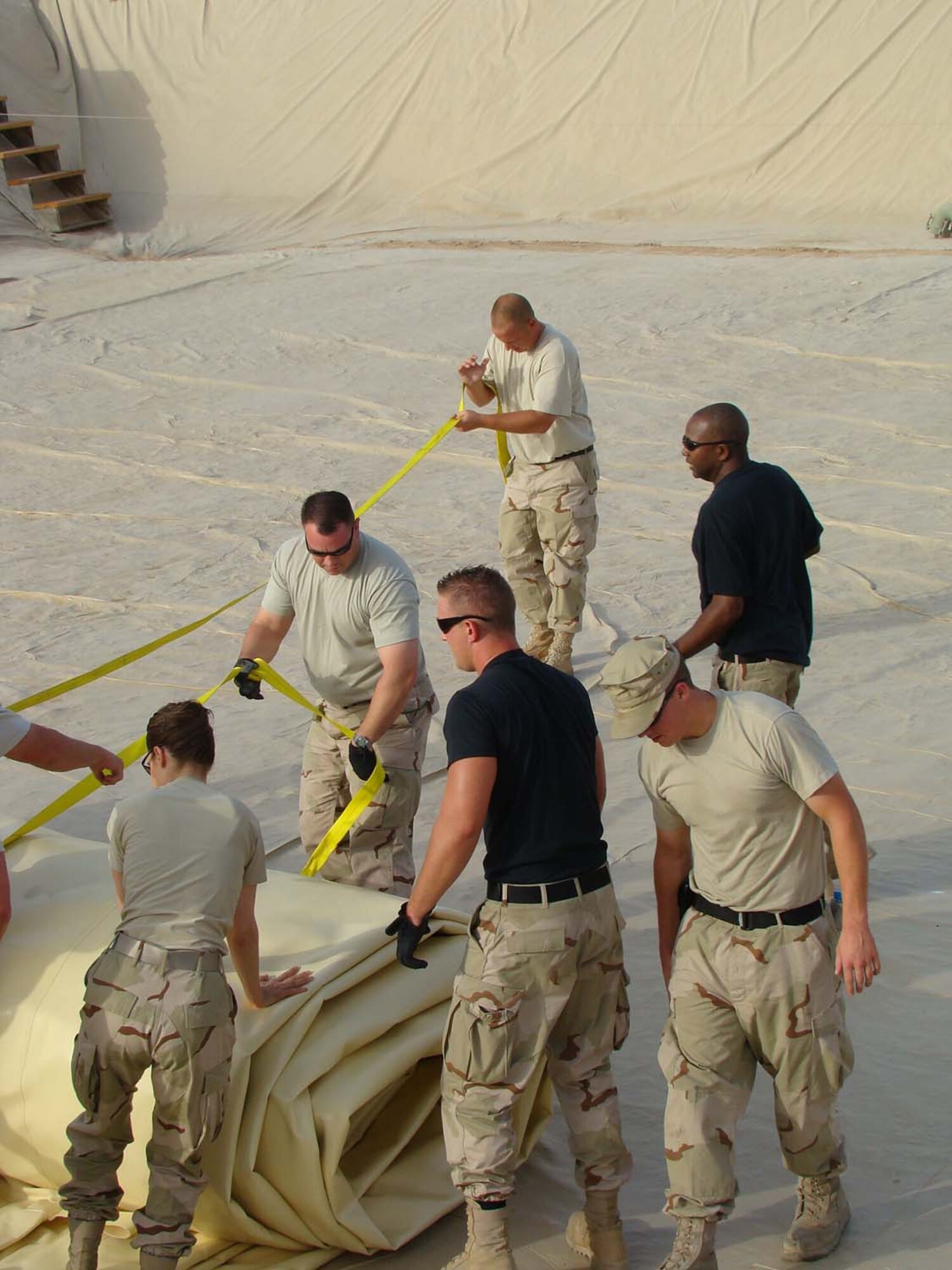 Volunteers joined the 380th Expeditionary Logistics Readiness Squadron to roll out a new fuel bladder Thursday. The fuel bladder weighs approximately 2.5 tons empty and it can hold 200,000 gallons of fuel. ELRS changed out the bladder Thursday due to normal wear and tear and climate conditions. (U.S. Air Force photo/Tech. Sgt. Denise Johnson)
                            