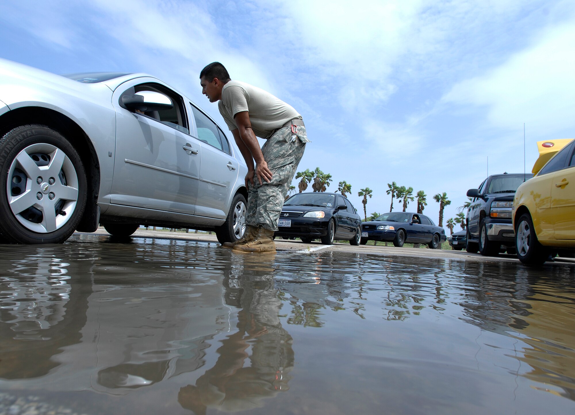 Army Spc. Jose Ramirez talks with a South Padre Island, Texas, resident looking for relief aid July 24 following Hurricane Dolly. Texas Task Force 1 members handed out nearly 4,000 bags of ice, 50 tons of water and 1,200 self-heating meals to hurricane vicitims. Specialist Ramirez is stationed with the 133rd Field Artillery at New Braunfels, Texas. (U.S. Air Force photo/Staff Sgt. Bennie J. Davis III)