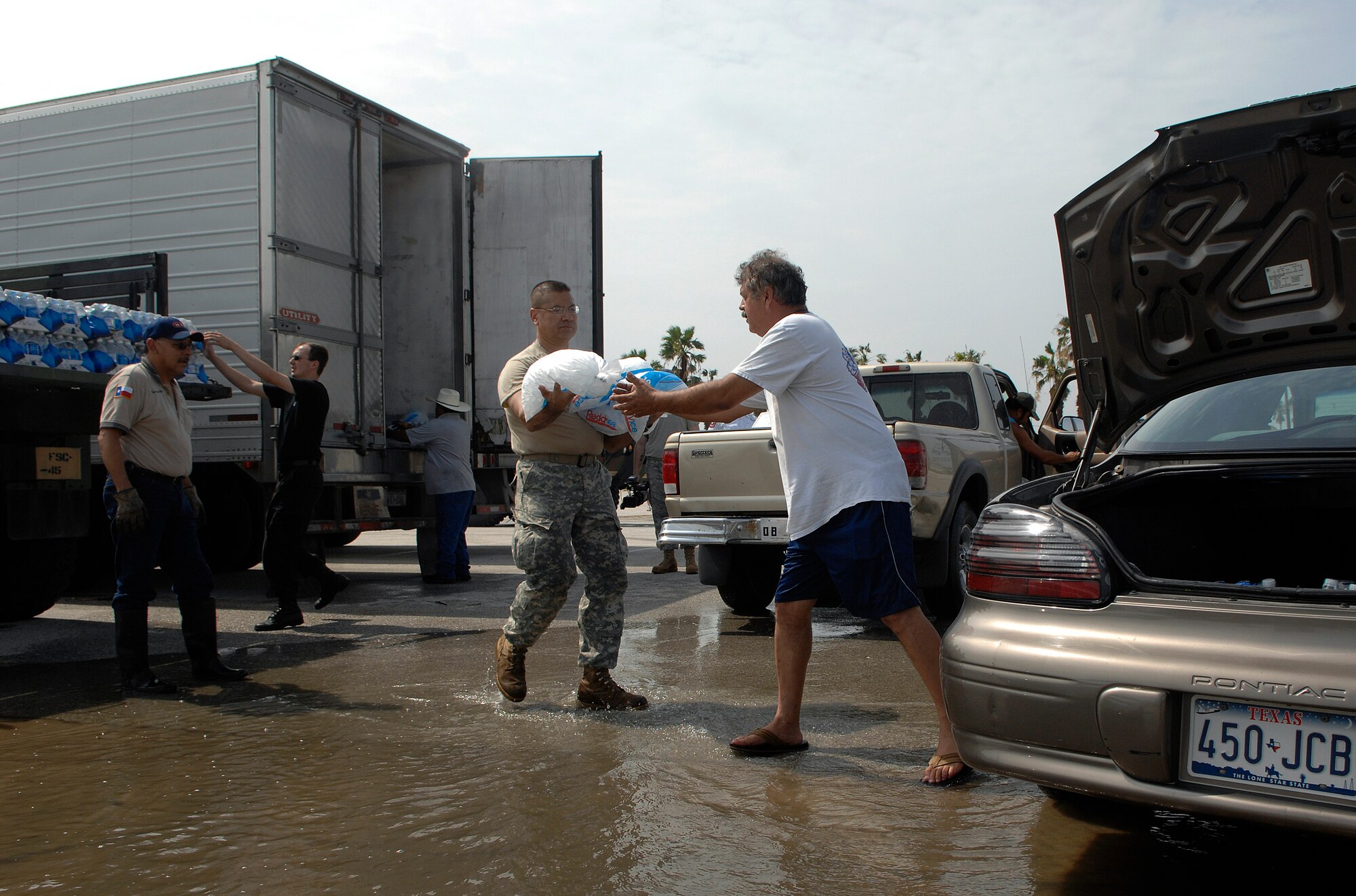 Army Spc. Luis Dominguez hands out bags of ice July 24 to residents of South Padre Island, Texas, the morning after the island was struck by Hurricane Dolly. Nearly 4,000 bags of ice, 50 tons of water and 1,200 meals were delivered to families by Texas Task Force 1 members. Specialist Dominguez is stationed with the 133rd Field Artillery at New Braunfels, Texas. (U.S. Air Force photo/Staff Sgt. Bennie J. Davis III) 