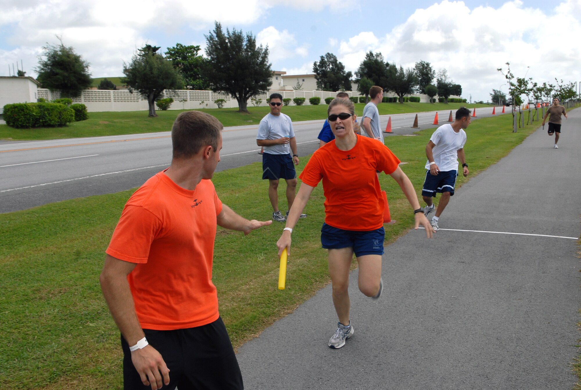 Capt. Vanessa Bartley, 961st Airborne Air Control Squadron, passes the baton to her teammate, Capt. Chris Easterly, as the 961st competed in the relay race during the Joint Services Fitness Challenge July 18. The fitness challenge gathered together 26 teams from various military branches and units to compete against one another in multiple exercise challenges.  Kadena’s own 31st Rescue Squadron walked away with the first and second place trophies and the opportunity to defend their title next year. (U.S. Air Force photo/Staff Sgt. Christopher Marasky) 