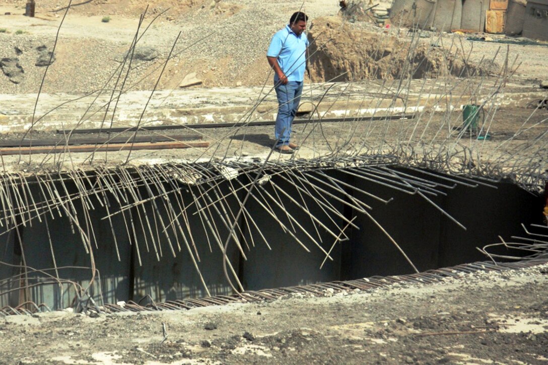 A manager from a local Iraqi construction company inspects the hole in the northbound lane of the Grand Canal Bridge in Taji, northwest of Baghdad, July 22, 2008. Workers are on schedule to have the repairs completed by the end of the year. U.S. Army photo by Pfc. Lyndsey R. Dransfield, Multinational Division Baghdad