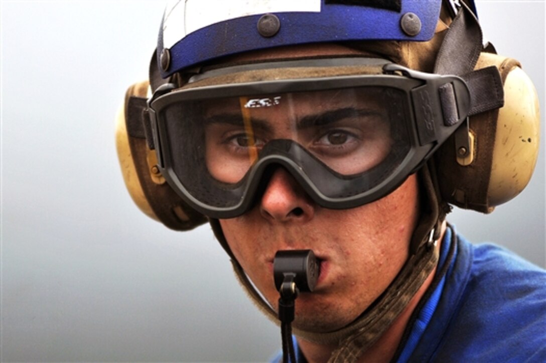 U.S. Navy Seaman Christopher Duguay, an aviation boatswain's mate, helps move aircraft on the flight deck of the aircraft carrier USS Abraham Lincoln, Gulf of Oman, July 8, 2008. The USS Lincoln is deployed to the U.S. 5th Fleet area of responsibility to support maritime security operations. 