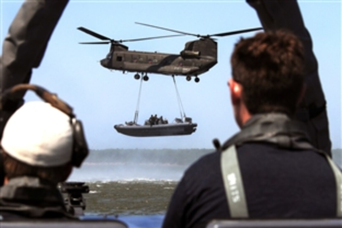 U.S. Navy special warfare combatant-craft crewmen on board a rigid hull inflatable boat observe an Army CH-47 Chinook helicopter lift another inflatable boat during a maritime external air transportation system training exercise in the Virginia Capes near Fort Eustis, Va., July 16, 2008. 