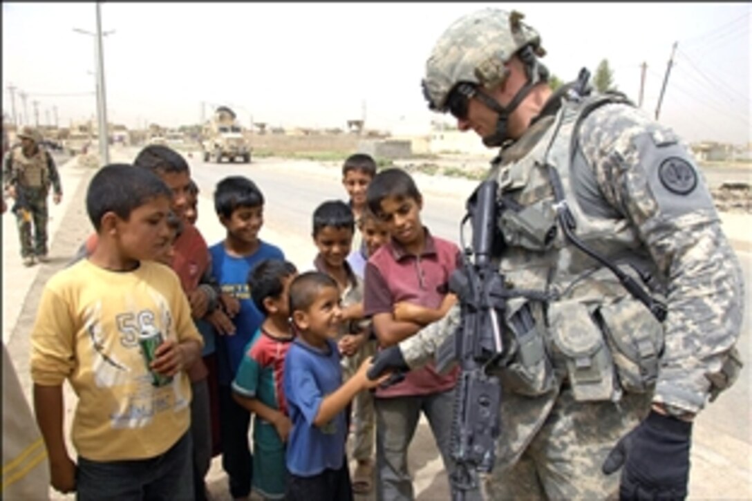 U.S. Army Capt. John Karcher makes some new friends with Iraqi boys in Mosul, Iraq, July 21, 2008. Karcher is assigned to the 3rd Battalion, 5th Brigade, 2nd Division Military Transition Team.