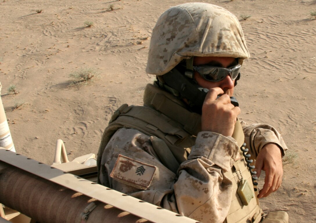 Convoy commander Sgt. Carlos Canez, a motor transport operator with Marine Wing Support Squadron 172, communicates with the vehicles in his convoy July 23 in al-Jazirah desert, Iraq. The 3rd Marine Aircraft Wing (Forward) support squadron brought home equipment from repair and replenishment point San Francisco. Canez is a Yuma, Ariz., native and currently on his third deployment to Iraq. (U.S. Marine Corps photo by Sgt.  George J. Papastrat) (Released)