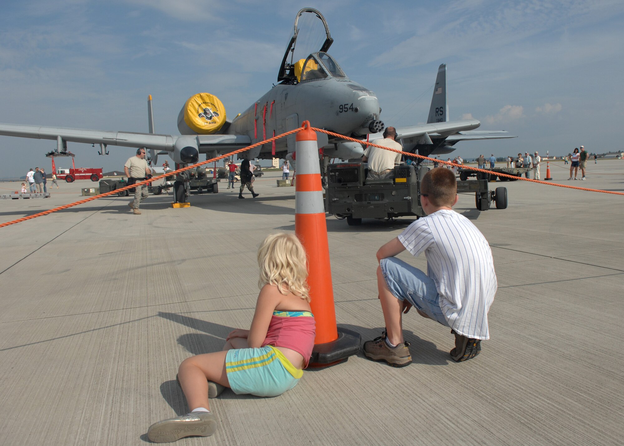SPANGDAHLEM AIR BASE, Germany – Young Open House visitors sit and observe aircraft maintenance group demonstrations, July 26, 2008. The Open House included static displays, and squadron demonstrations. (U.S. Air Force photo by Airman Staci Miller)