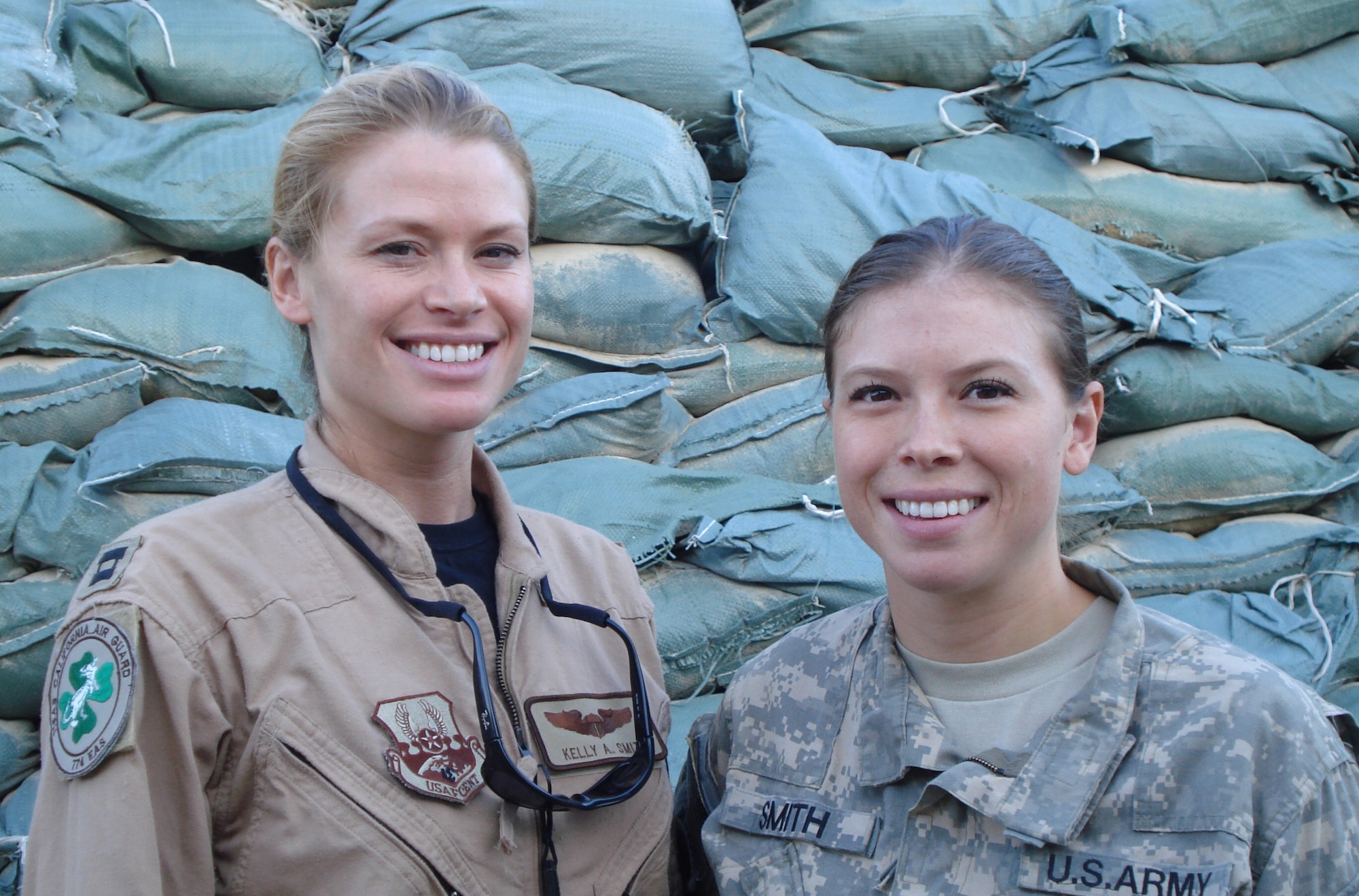 BAGRAM AIR FIELD, Afghanistan -- Capt. Kelly Smith and Army Chief Warrant Officer Amber Smith, sisters from White Salmon, Wash., pose for a picture together here July 15, 2008. Captain Smith, a C-130 pilot, and Warrant Officer Smith, a OH-58 Kiowa pilot, both deployed to Afghanistan and spent a few weeks together at Bagram. (U.S. Air Force photo by Staff Sgt. Rachel Martinez)