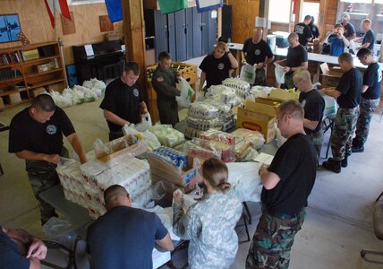 JTF-Bravo military members pack individual bags July 25 from the $900 worth of food purchased for the next day's chapel hike. More than 100 military members and civilians from Soto Cano packed the food in more than five miles to Mira Valle for the people of the village. (U.S. Air Force photo by Tech. Sgt. John Asselin)