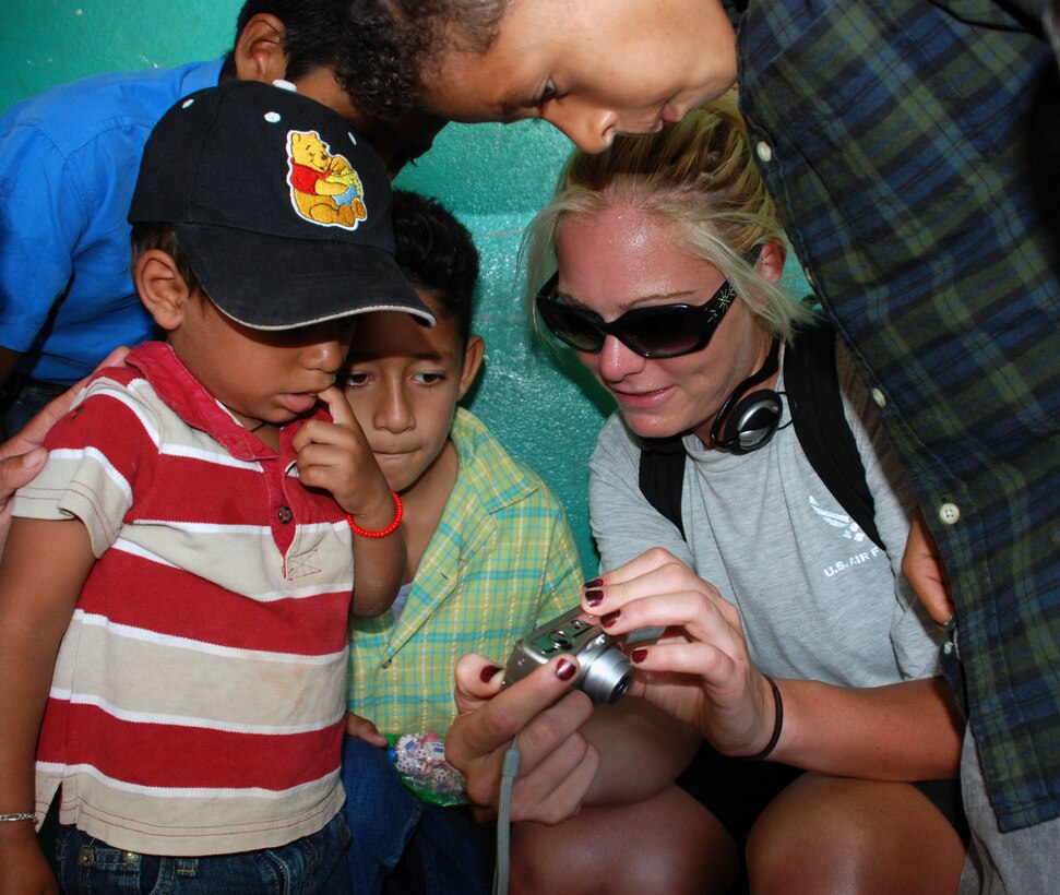 Air Force Senior Airman Ashley Gordon, a weather forecaster with the 612th Air Base Squadron, shows children in Mira Valle village their photos on a digital camera. Military members and civilians from JTF-Bravo packed in nearly 1,600 pounds of food to the village July 26. (U.S. Air Force photo by Tech. Sgt. John Asselin)