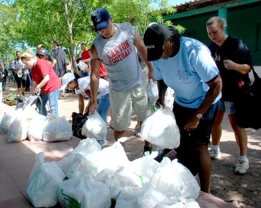 Military members from Joint Task Force-Bravo unpack food they hiked into Mira Valle village in Honduras. The more than 100 troops from Soto Cano Air Base walked more than five miles to bring $900 worth of food the people in the village. (U.S. Air Force photo by Tech. Sgt. John Asselin)