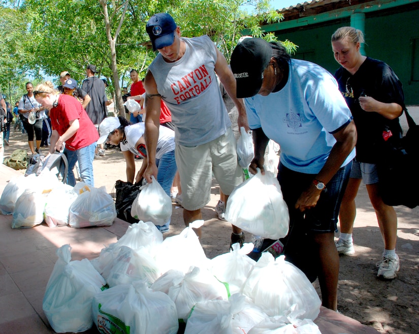 Military members from Joint Task Force-Bravo unpack food they hiked into Mira Valle village in Honduras. The more than 100 troops from Soto Cano Air Base walked more than five miles to bring $900 worth of food the people in the village. (U.S. Air Force photo by Tech. Sgt. John Asselin)