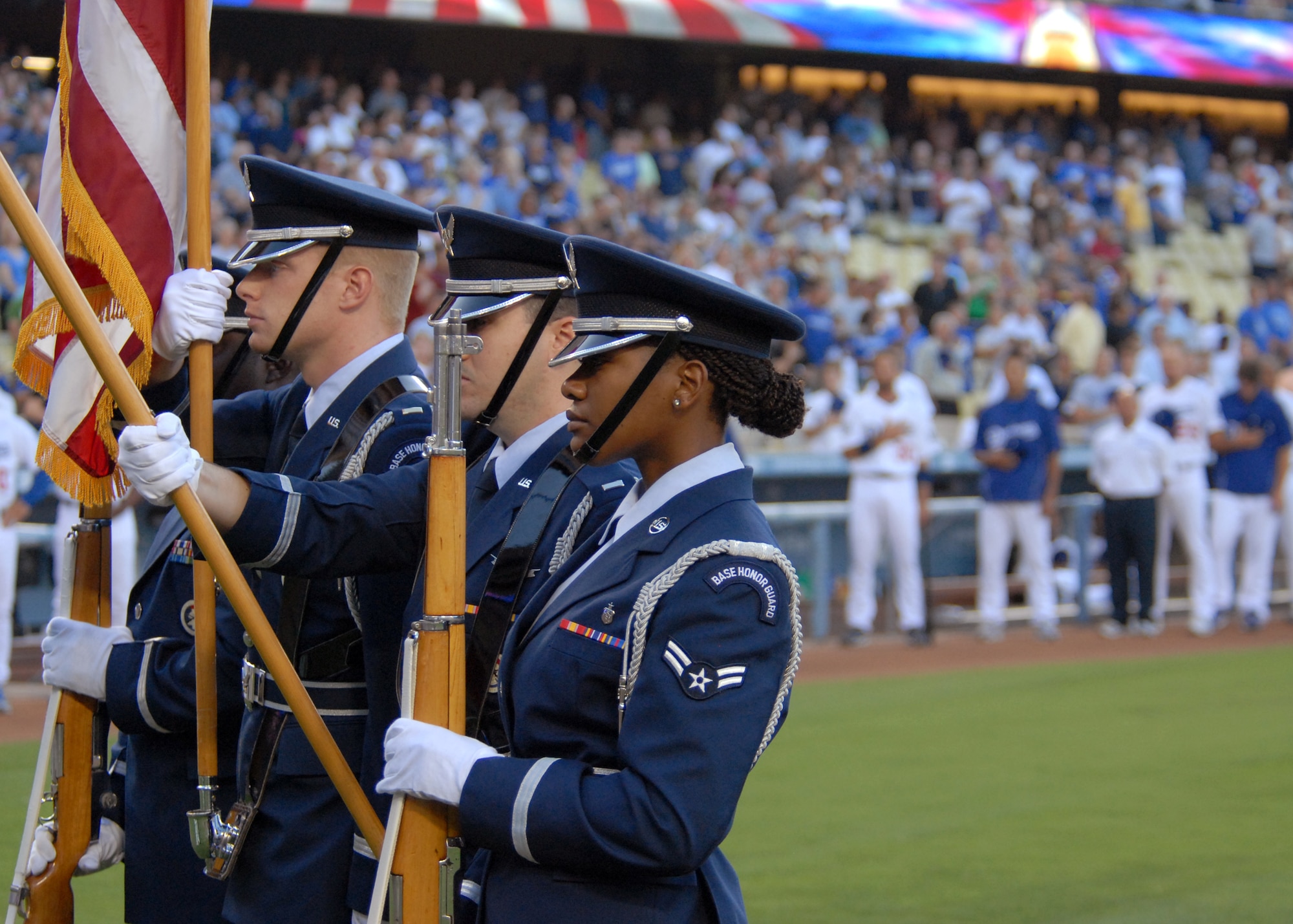 Los Angeles AFB Honor Guard post the colors during the national anthem as members of the Los Angeles Dodgers in the background places their hats over their hearts at the beginning of the Dodger game celebrating the city of El Segundo, July 26. (Photo by Stephen Schester)