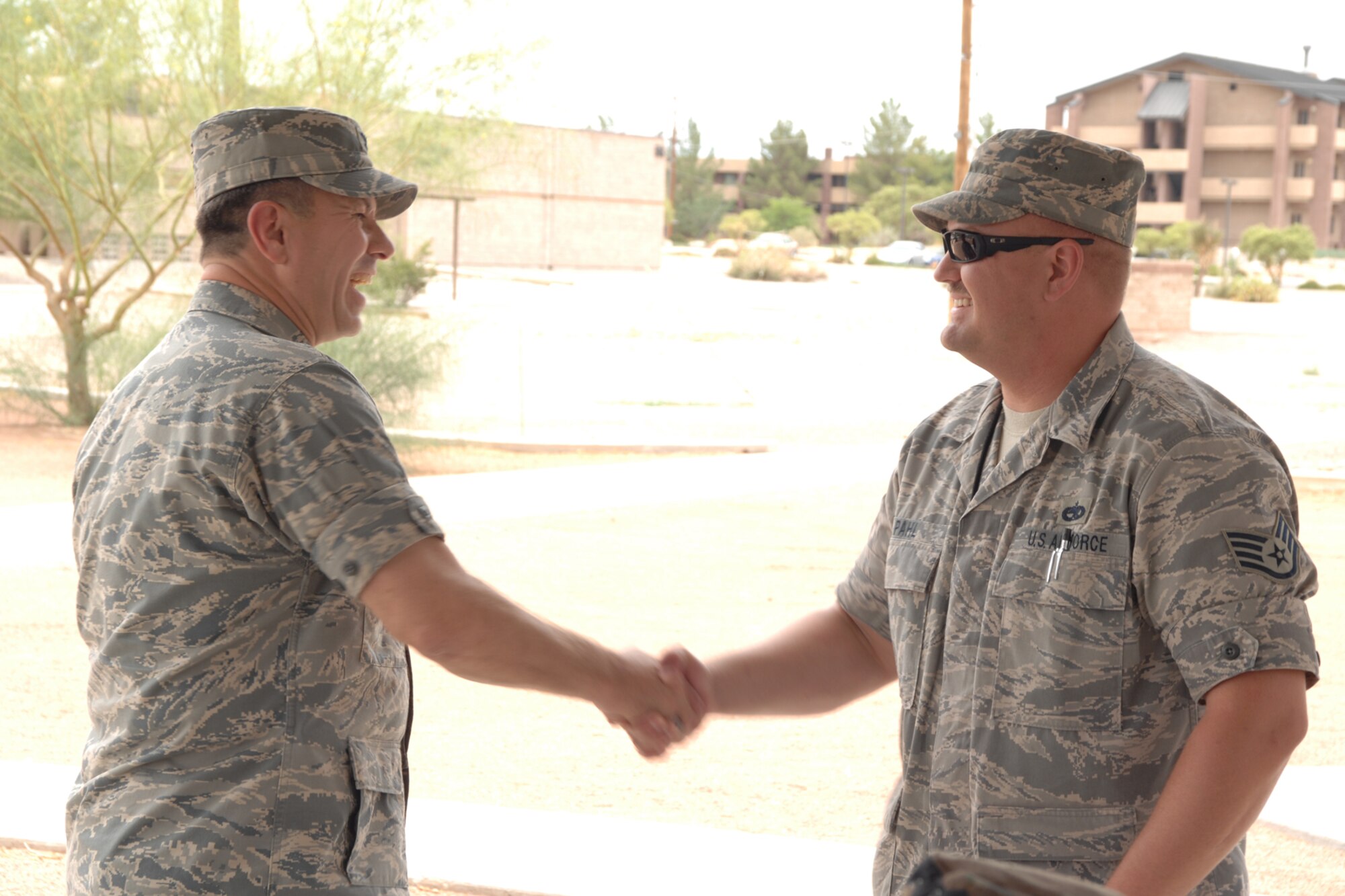 Staff Sgt. Edward Pahl, 49th Maintenance Group, receives a coin from Col. GeorgeTorres, 49 MXG commander, during the Keep America Beautiful wrap up June 27 at Holloman Air Force Base, N.M. (U.S. Air Force photo/Airman 1st Class Jamal D. Sutter)