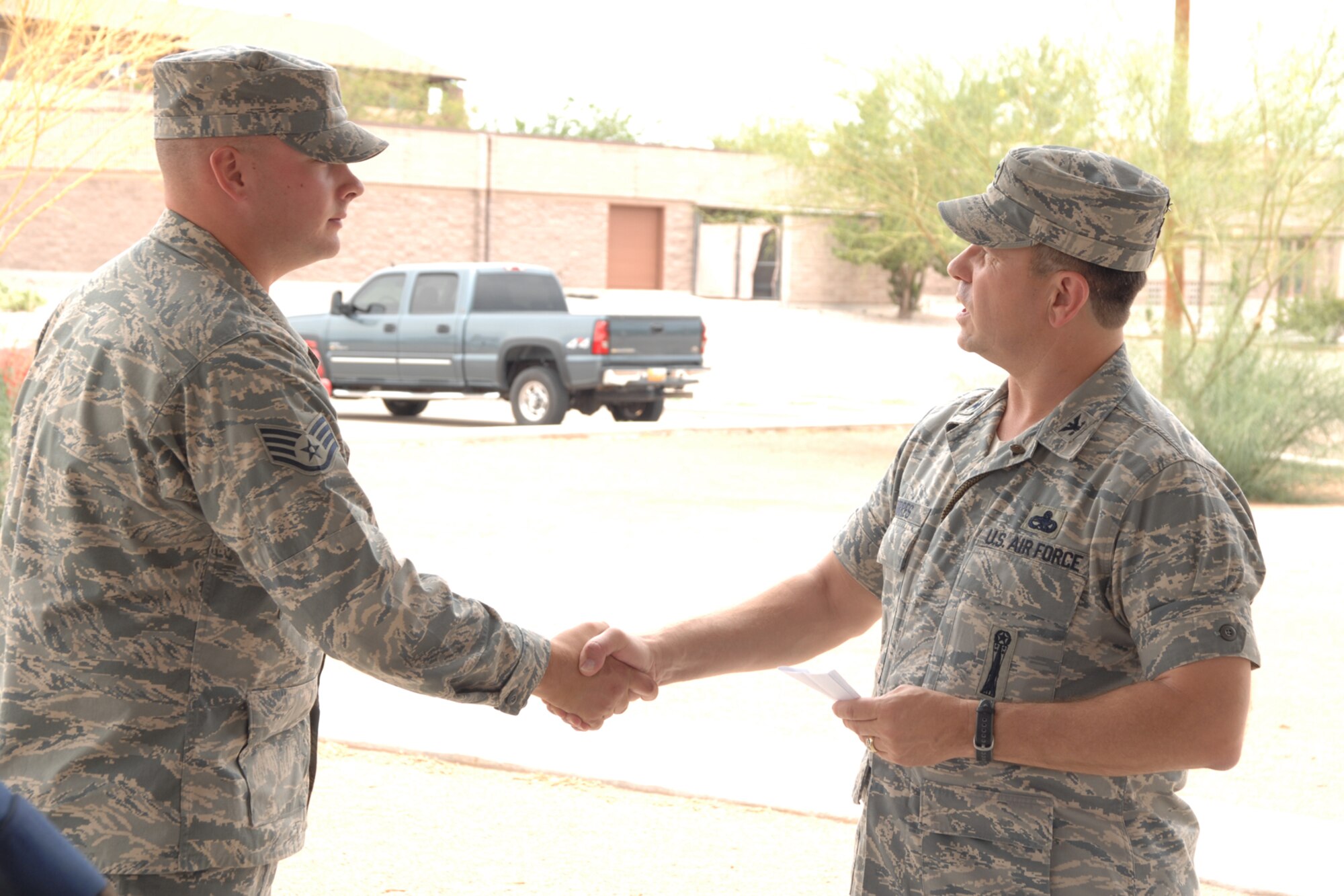 Staff Sgt. Damian Horton, 49th Aircraft Maintenance Squadron, receives a coin from Col. GeorgeTorres, 49th Maintenance Group commander, during the Keep America Beautiful wrap up June 27 at Holloman Air Force Base, N.M. (U.S. Air Force photo/Airman 1st Class Jamal D. Sutter)