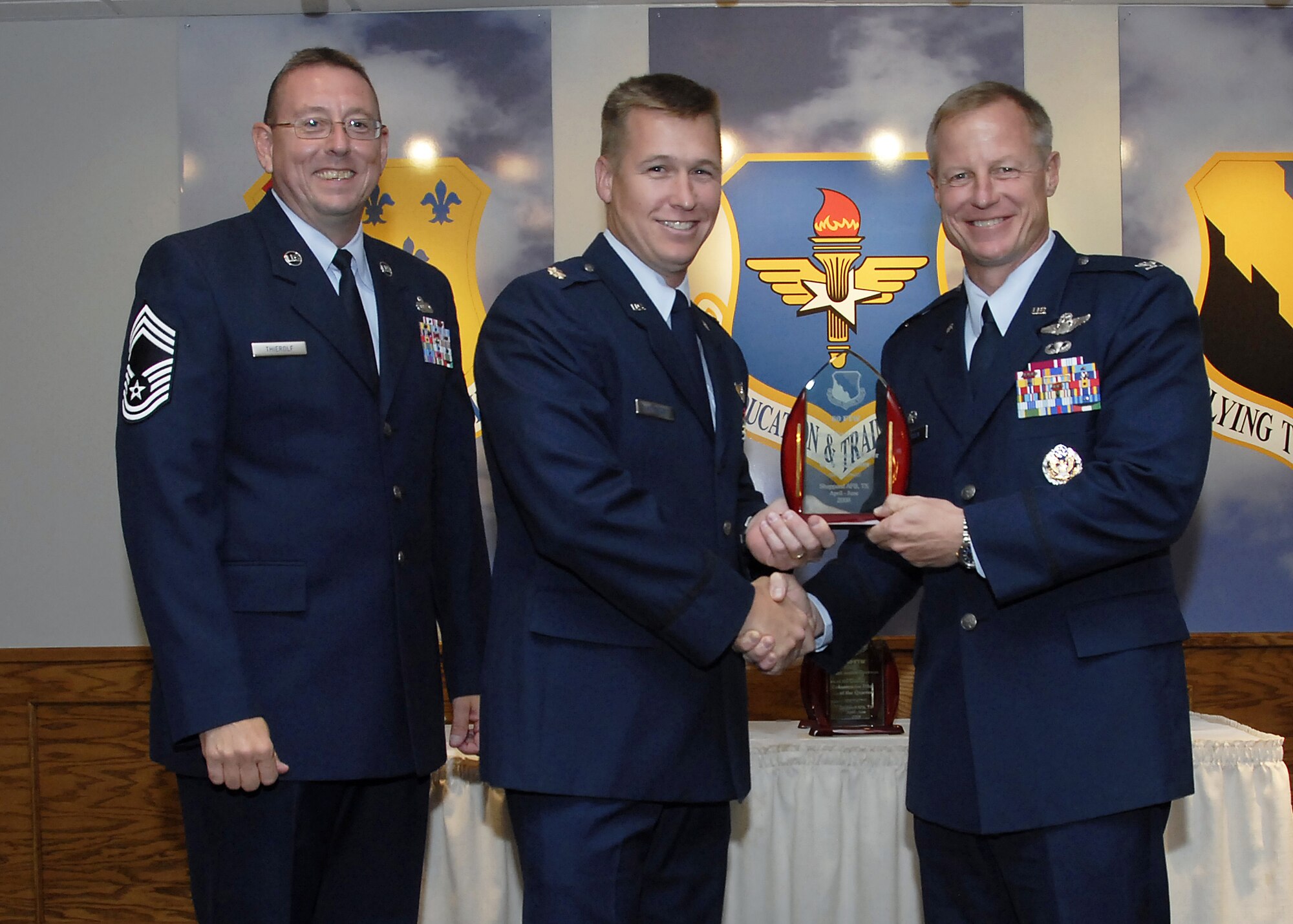 Maj. Errol Rottman, center, accepts the Field Grade Officer of the Quarter award from 80th Flying Training Wing Commander David Petersen July 22 at the wing's quarterly awards banquet. Also pictured is wing Superintendent Chief Master Sgt. Norman Thierolf. (U.S. Air Force photo/Mike Litteken)