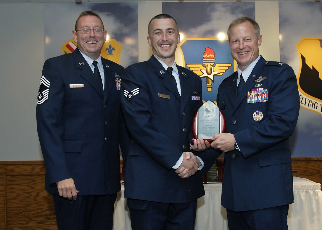 Senior Airman Kristopher Koelling, center, accepts the Airman of the Quarter award from 80th Flying Training Wing Commander David Petersen July 22 at the wing's quarterly awards banquet. Also pictured is wing Superintendent Chief Master Sgt. Norman Thierolf. (U.S. Air Force photo/Mike Litteken)