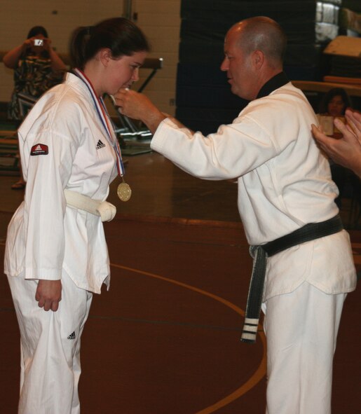 MINOT AIR FORCE BASE, N.D. – Capt. Kera Averill, 23rd Bomb Squadron electronics warfare officer, receives her gold and silver medals after a dominating martial arts performance during the North Dakota Prairie Rose Games in Minot July 12. Captain Averill is a Tae Kwon Do white-belt. (U.S. Air Force photo by Master Sgt. Ron Tolzin) 
