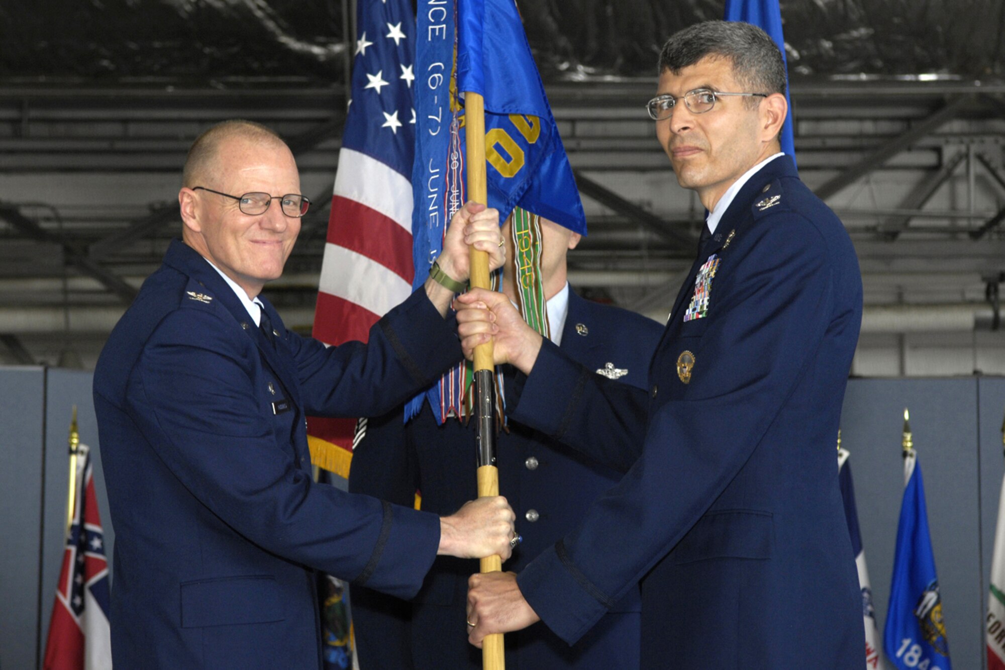 (Left) Col. Paul R. Ackerley, 316th Wing commander, passes the guidon to Col. Clair Gilk, the new 316th Operations Group commander on July 18. Colonel Gilk arrived from Carlisle Barracks, Penn., where he was a faculty instructor for the Army War College. He is a command pilot with 4,770 hours in the TH-55, UH-1H, MH-60G and HH-60G helicopters.