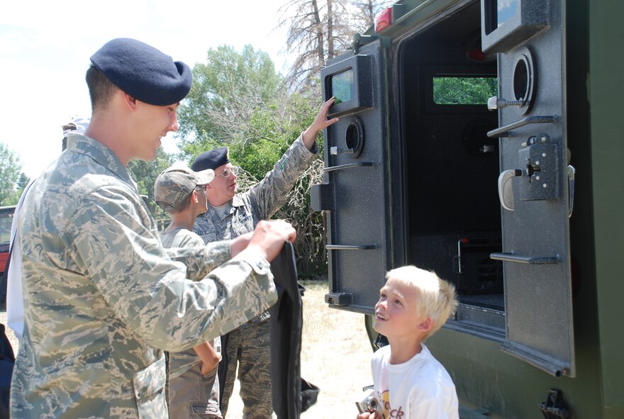A security forces Airman shows an open house attendee equipment July 19 (Photo by Senior Airman Connor Burkhard).