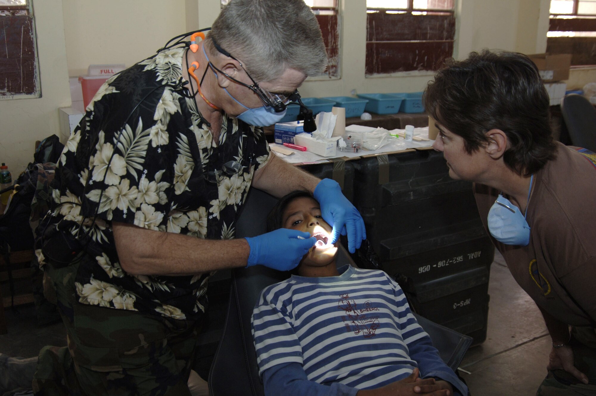 Navy Capt. Dennis Romary, with the help of Hospital Corpsman 1st Class Ilisa Kleifield, performs a dental exam on a Peruvian patient at San Juan Bautista, July 21.  The Navy's Opeational Health Support Unit from Great Lakes, Ill., is supporting New Horizons 2008 Peru, U.S. Southern Command's annual program to provide humanitarian assistance to Latin and Carribbean nations, through three missions to provide free medical services to the Peruvian people of the Ayacucho region, July 21 to 31. (U.S. Air Force photo/Capt. David Tomiyama)