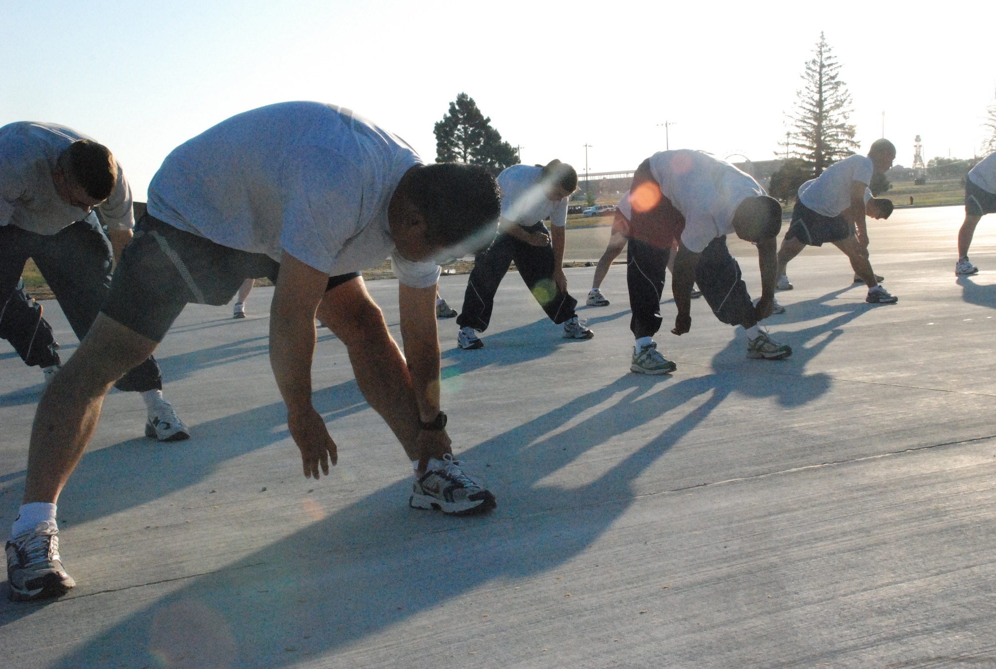 Airman from the 90th Civil Engineer Squadron perform pre-workout stretches on the new stretch pad near Freedom Hall Fitness Center July 17. The new pad is accompanied by a parking lot. Warren members are encouraged to use the stretch pad when using the running track around Argonne Parade Field (Photo by 1st Lt. Lisa Meiman).
