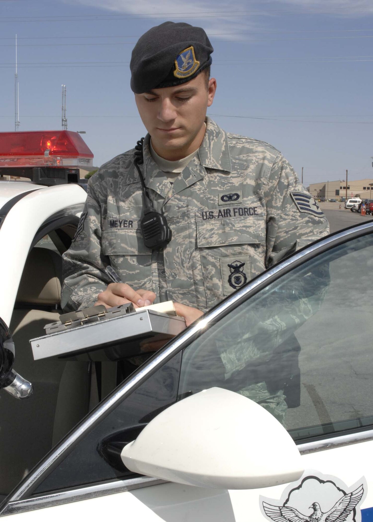Staff Sgt. Jeremy Meyer, 49th Security Forces Squadron Alpha Flight patrolman, writes out a ticket for speeding, July 25 at Holloman Air Force Base, N.M. The squadron protects the F-22 Raptor, as well as Air Force Space Command and other associate units' resources. (U.S. Air Force photo/Airman 1st Class Rachel A. Kocin)