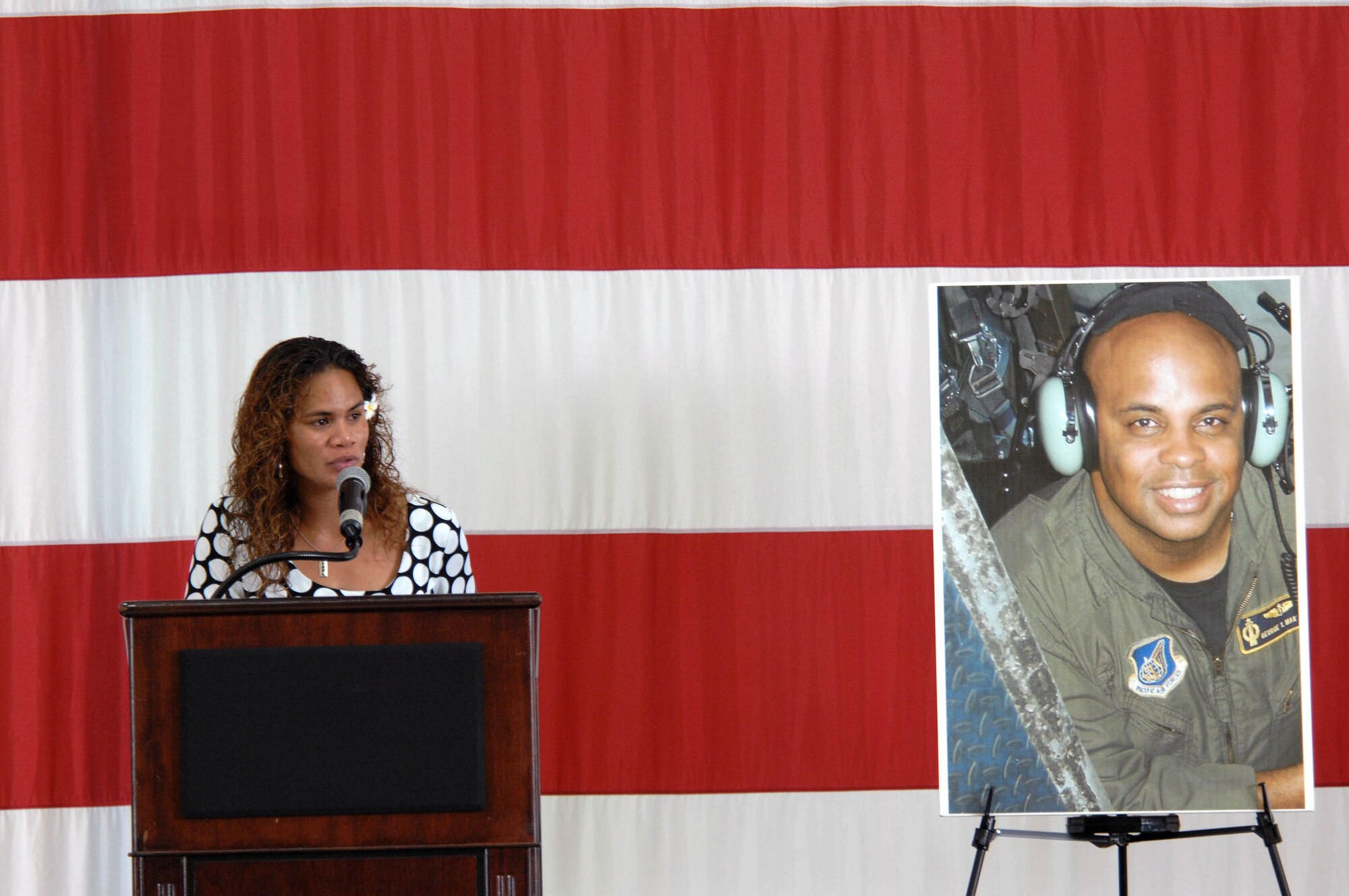 Ursula Martin, wife of Col. George Martin, thanks the myriad of agencies July 25 for their search for the Airmen who lost their lives in the July 21 B-52 crash. Colonel Martin, 36th Medical Group deputy commander, was on "Raider 21" when it crashed 25 miles off the coast of Guam. Mrs. Martin, who stands next to a photo of her husband, also extended her gratitude to Andersen's Airmen and families for their support and shared her condolences with the families of the other aircrew members. (U.S. Air Force photo/Airman 1st Class Corey Todd)