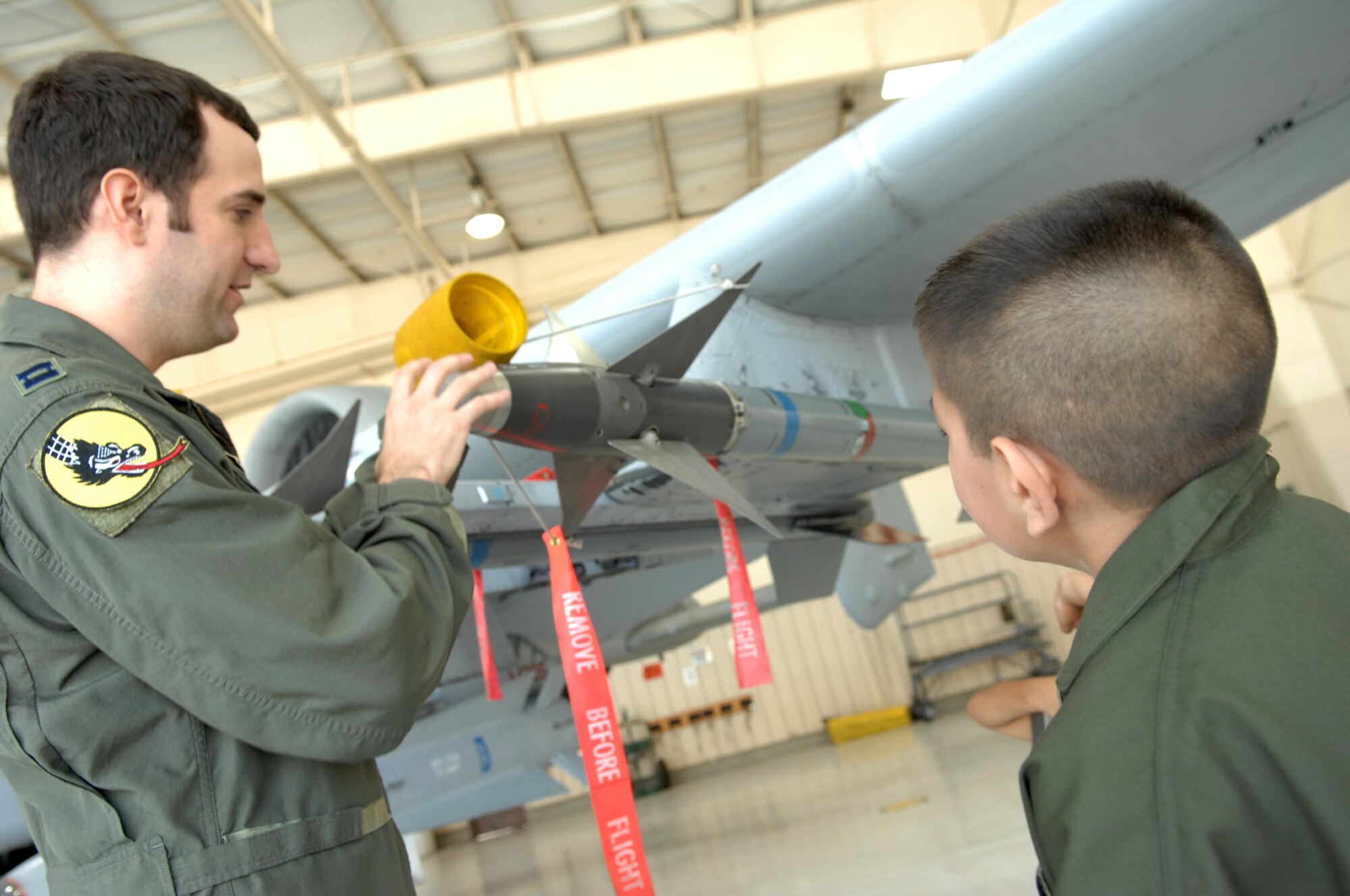 Capt. John "Bus" Buske, 357th Fighter Squadron pilot, explains to Andrew Valdez, 13 years old, the features of an A-10 Thunderbolt II during Andrew's visit to D-M on July 25. (U.S. Air Force photo/Senior Airman Noah R. Johnson)