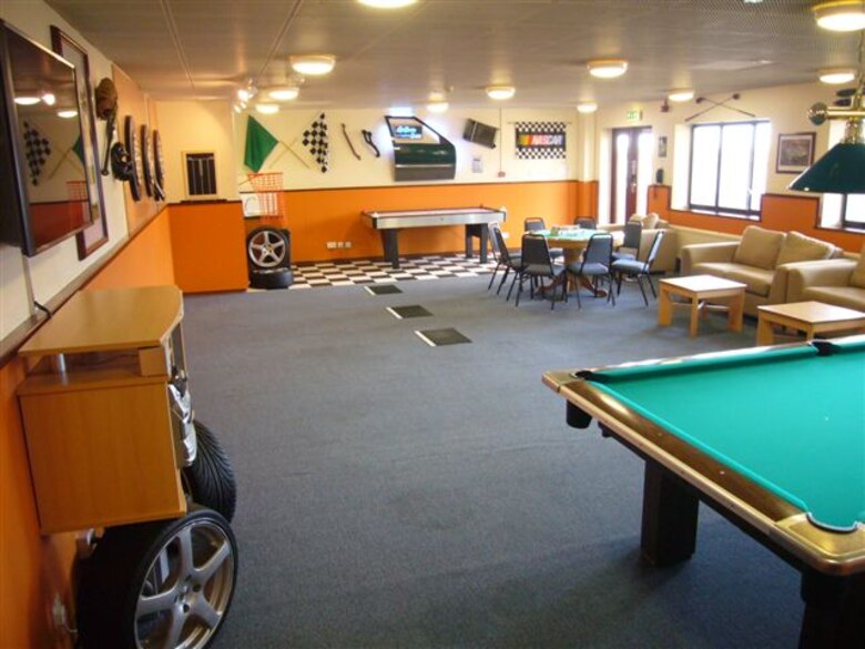 A view of the new Sports Den created as part of the newly dedicated 423rd Air Base Group Dormitory renovation and morale project.  A car door refurbished with bold LED lighting is the signature feature of the Sports Den created by Dorm Manager Air Force Technical Sgt. Phillip Allen. Sgt. Allen found the door at a local dump. The project was dedicated by Air Force Colonel Kimberly K. Toney, 51st Combat Support Wing Commander and leadership of the JIOCEUR Analytic Centert, 423rd Air Base Group, and dorm residents. (U.S. Air Force photo by Technical Sgt. Phillip A. Allen)