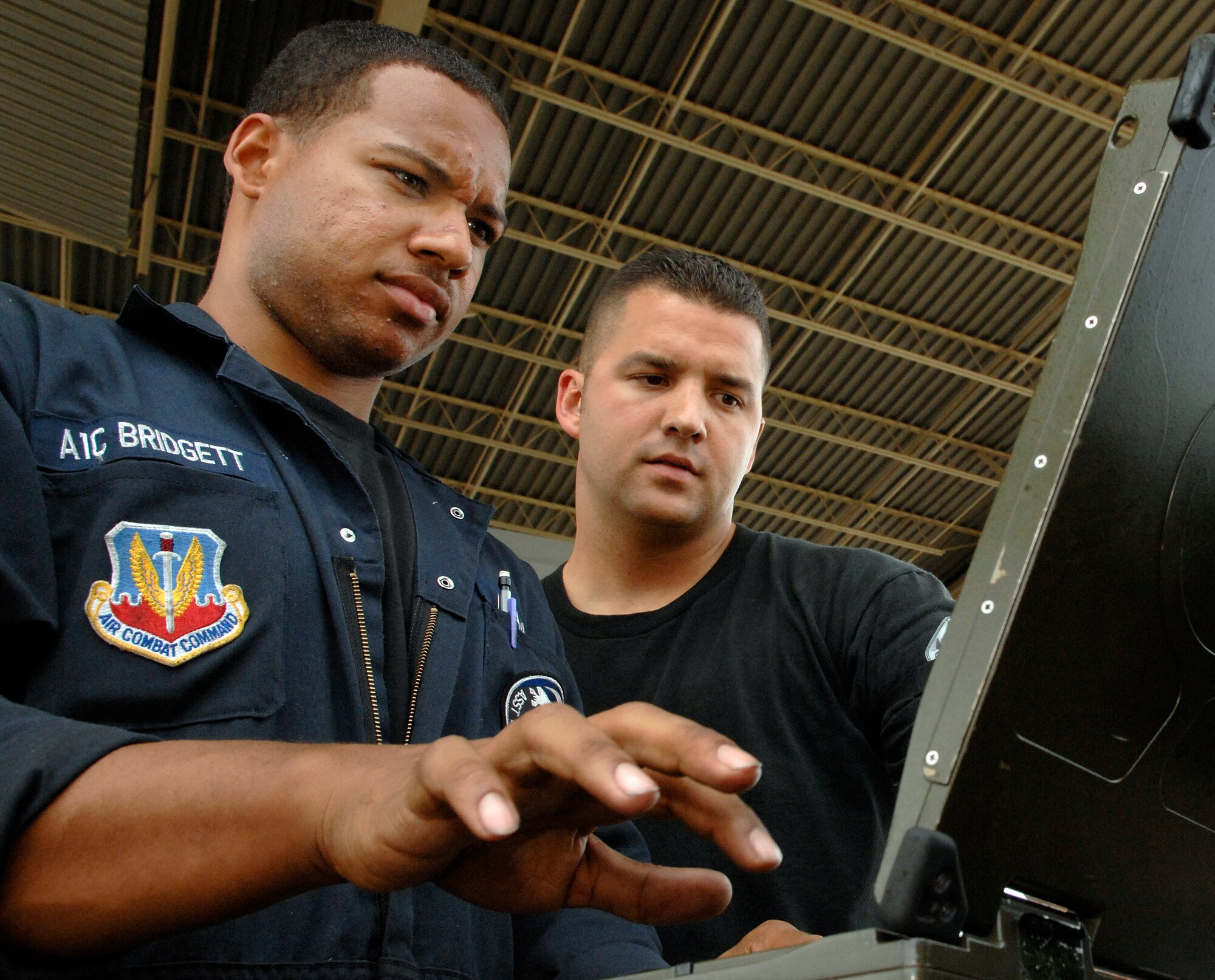LANGLEY AIR FORCE BASE, Va -- Airman 1st Class Kian Bridgett and Tech. Sgt. Stephen Silva, 94th Aircraft Maintenance Unit crew chiefs , review data during a post flight inspection of an F-22A Raptor that returned from Combat Archer July 25.  Combat Archer is an air-to-air system evaluation in which pilots test the reliability and effectiveness data of aircraft and missiles and complete required training for their Air Expeditionary Force cycle.   (U.S. Air Force photo/Senior Airman Vernon Young) 