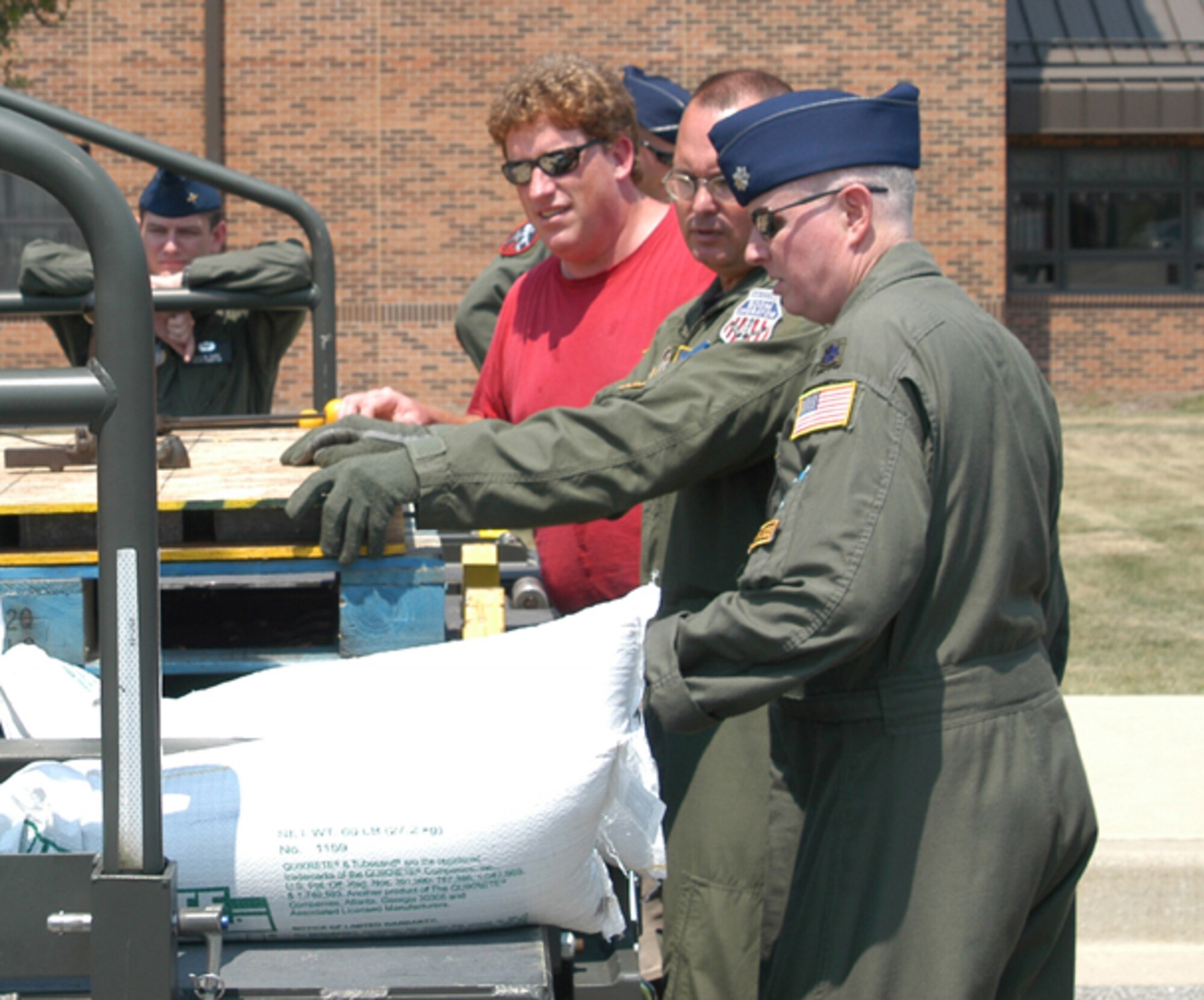 GRISSOM AIR RESERVE BASE, Ind., -- Lt. Col. Thom Pemberton (right) and Master Sgt. Scott Ward, both of the 434th Air Refueling Wing, and Jere Jenkins, Purdue University, review items belonging a scientific research team.  Pemberton and Ward are aircrew members on a KC-135R Stratotanker that transported a 13-person research team to Thule Air Base, Greenland.  The team included representatives from Purdue University and the Air Force Academy.  (U.S. Air Force photo/Lt. Col. Gary Lockard)                          
