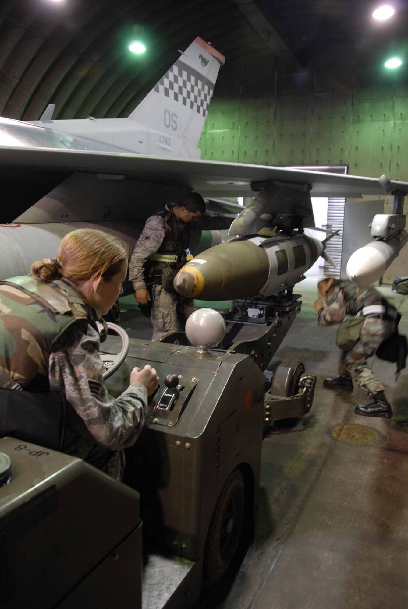 Senior Airman Brooke Turnipseed (left to right), Airman 1st Class Justin Campbell and Staff Sgt. Dominique Rubisch work together to download a live joint direct attack munitions from an F-16 Fighting Falcon during the base-wide exercise July 21 at Osan Air Base, South Korea. The operational readiness exercise tests the Osan AB Airmen's ability to execute combat operations, receive follow-on forces and defend the base from attack. The Airmen are all 51st Aircraft Maintenance Squadron weapons loaders. (U.S. Air Force photo/Staff Sgt. Lakisha Croley) 