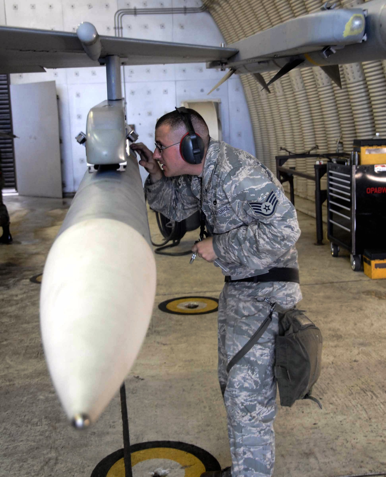 Staff Sgt. Andrew Stover inspects the AIM-120 connections on an F-16 Fighting Falcon during a base-wide exercise July 21 at Osan Air Base, South Korea. Exercise scenarios test the Osan AB Airmen's ability to defend the base and conduct daily operations in a combat environment. Sergeant Stover is a 51st Aircraft Maintenance Squadron weapons loader. (U.S. Air Force photo/Staff Sgt. Lakisha Croley) 