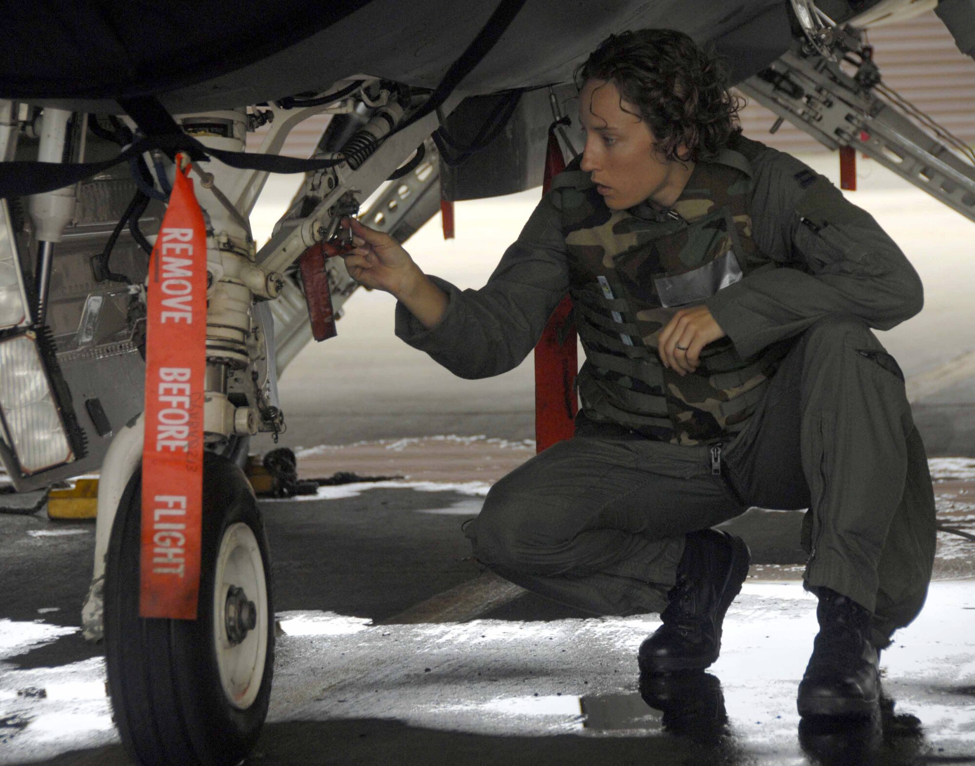 Capt. Kristin Hubbard checks the landing gear on her F-16 Fighting Falcon during a base-wide exercise July 21 at Osan Air Base, South Korea. Captain Hubbard is a 36th Fighter Squadron pilot. The operational readiness exercise tests Osan AB Airmen's ability to execute combat operations, receive follow-on forces and defend the base from attack. (U.S. Air Force photo/Senior Airman Christopher Boitz)