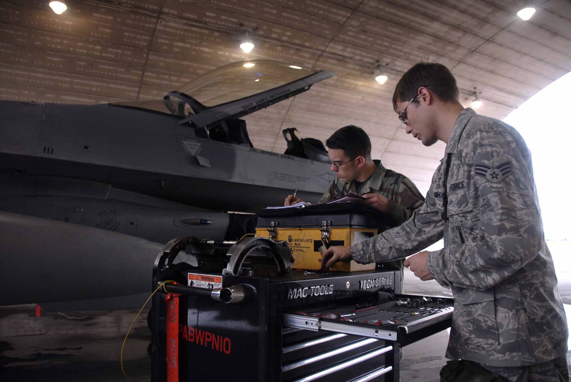 OSAN AIR BASE, Republic of Korea -- (From right to left) Airman 1st Class John Bumbalough and Senior Airman Mark Mihasci record information and perform a tools inspection here July 21, after preparing an F-16 aircraft for an upcoming mission. Both Airmen are Weapons Armament Specialists assigned to the 51st Aircraft Maintenance Squadron. (U.S. Air Force photo/Senior Airman Christopher Boitz)