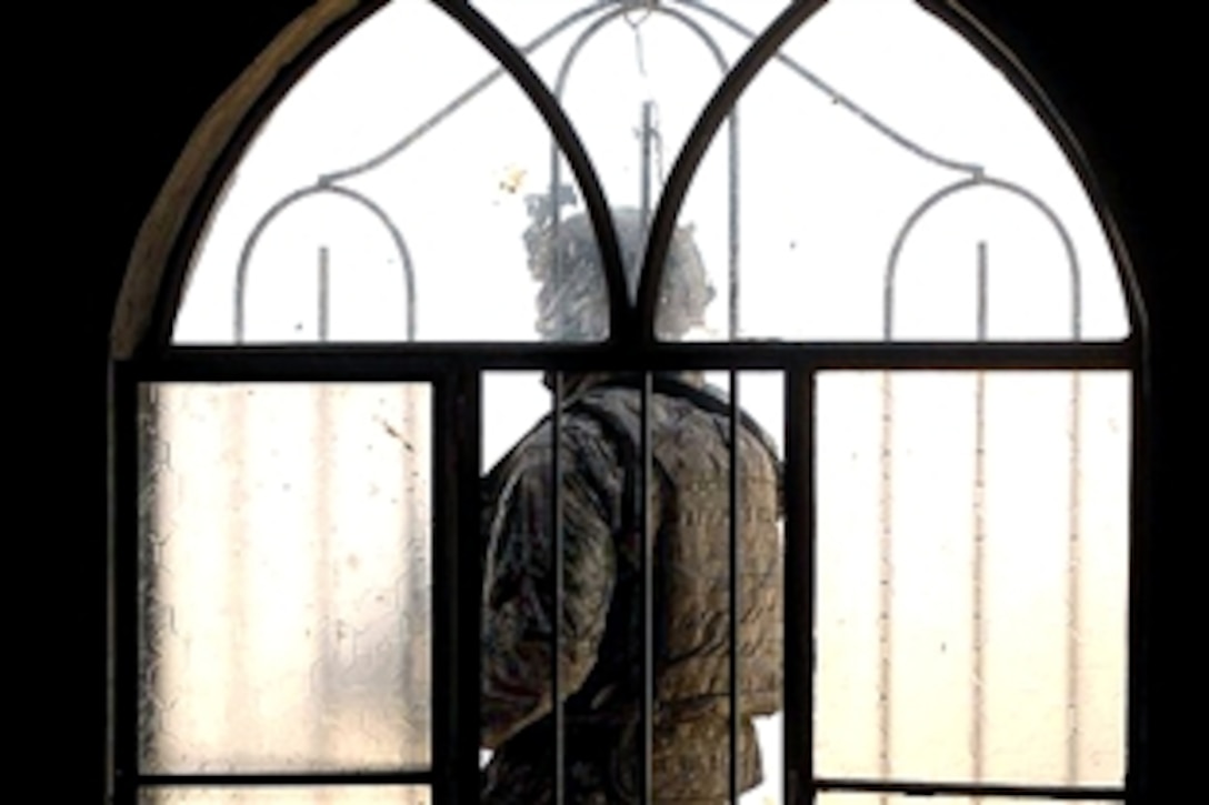 A U.S. Army soldier stands guard outside a home being searched for weapons caches in Balad, Iraq, July 24, 2008. The soldier is assigned to the 101st Airborne Division's Company A, 2nd Battalion, 327th Infantry Regiment.

