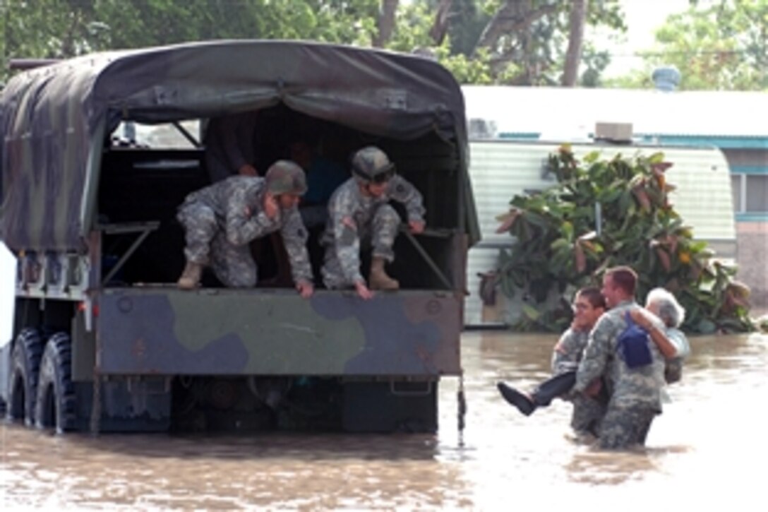 Texas National Guard soldiers carry a woman stranded by flood waters caused by Hurricane Dolly to a waiting truck off State Highway 77 near Harlingen, Texas, July 25, 2008. The soldiers are, from left, Pfc. John Paul Borrego, Pfc. Christopher Culbelier, Pfc. Mark Rivera and Pfc. Joseph Davora. They are with the Texas National Guard's 72nd Infantry Brigade and 41st Infantry Regiment. 