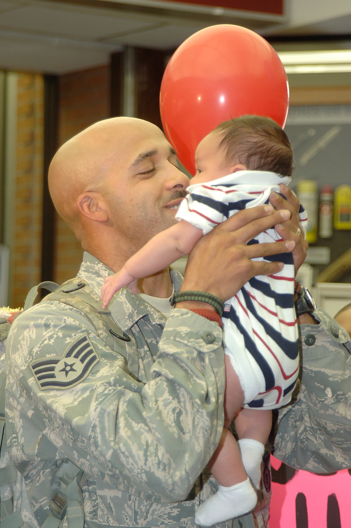 MCCONNELL AIR FORCE BASE, Kan. -- Staff Sgt. Terrance Williams, 22nd Security Forces Squadron embraces his six-week-old son, Terrance, for the first time at Wichita Mid-Continent Airport , July 27, after returning home from a six month deployment to Iraq.  His son was born while he was deployed.   (Photo by Airman 1st Class Jessica Lockoski)